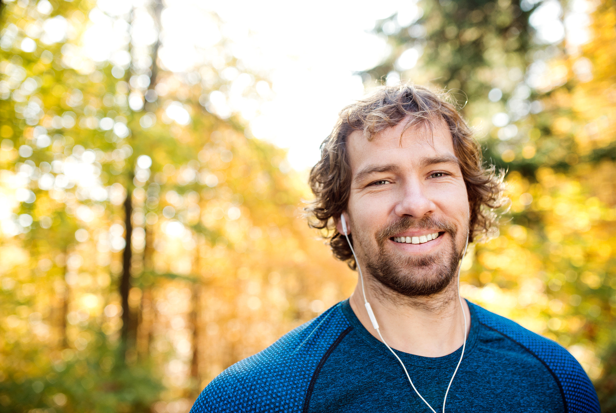 Nikon D4S + Sigma 35mm F1.4 DG HSM Art sample photo. Young handsome runner with earphones outside in autumn nature photography