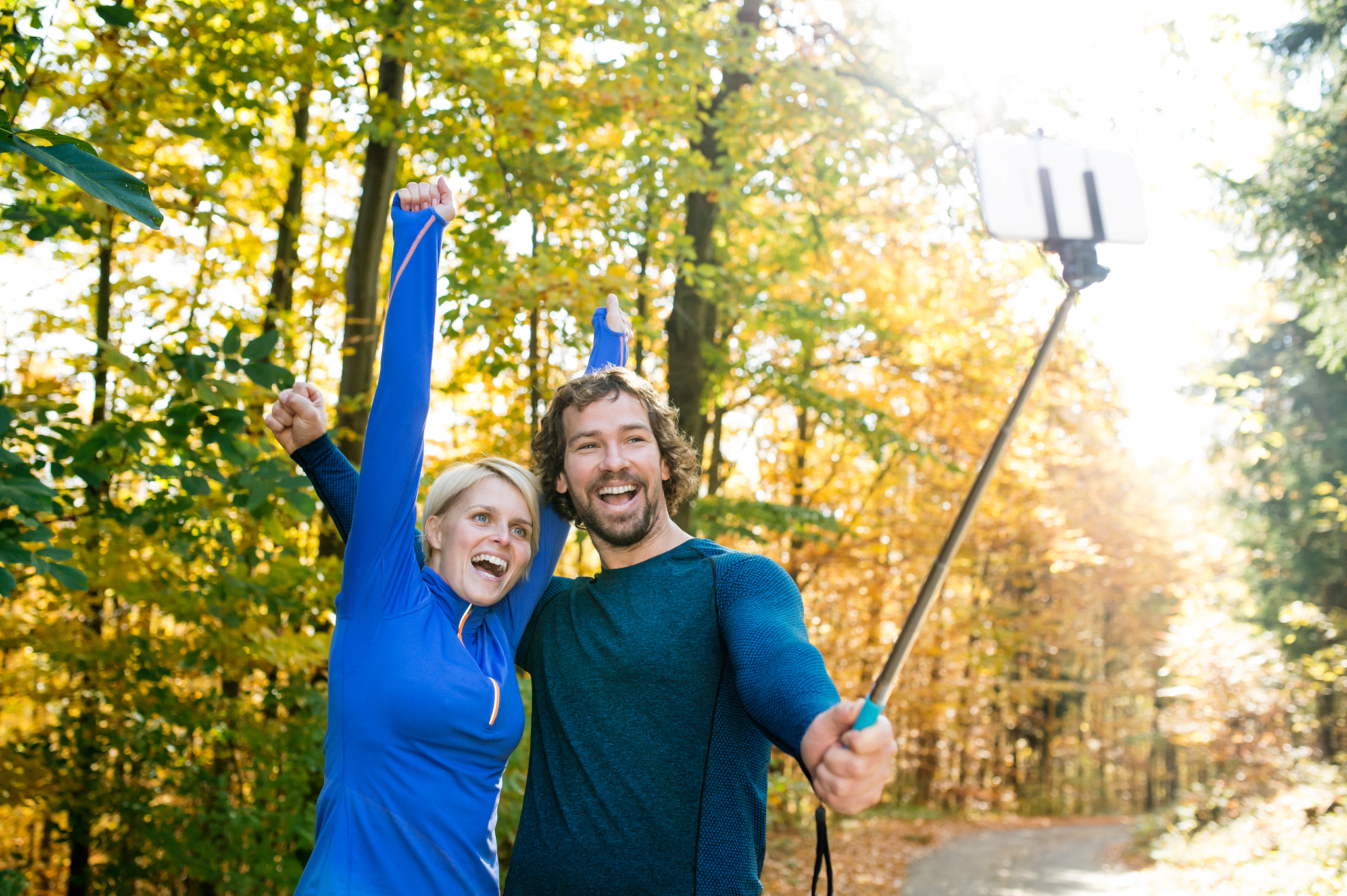 Nikon D4S + Sigma 35mm F1.4 DG HSM Art sample photo. Beautiful runners in autumn forest taking selfie with smartphone photography