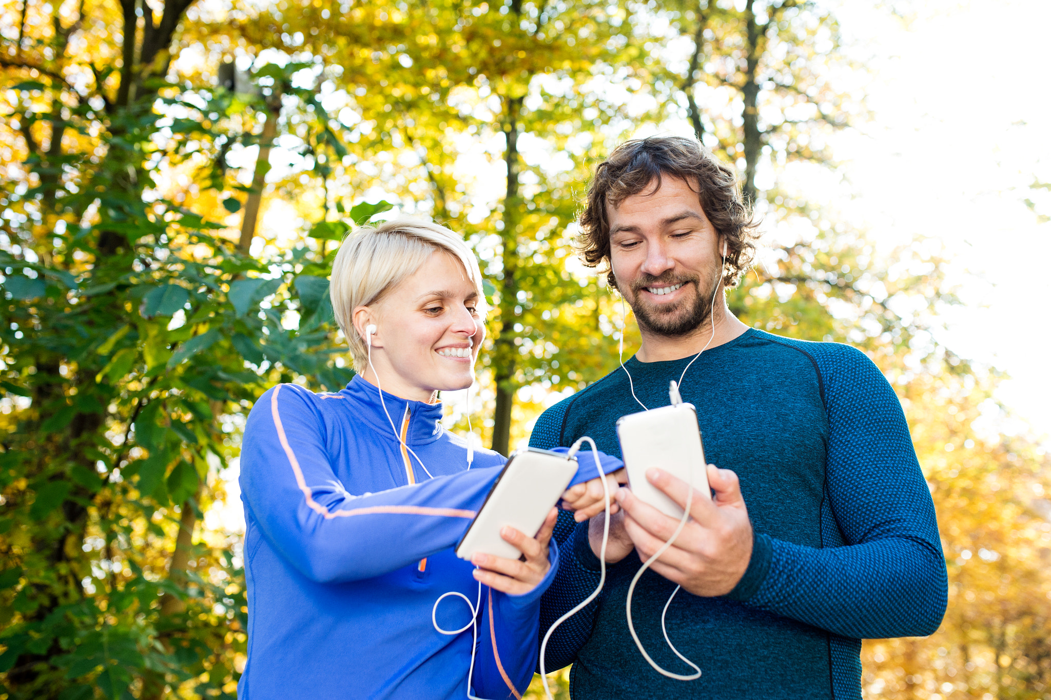 Nikon D4S sample photo. Running couple with smart phones and earphones photography