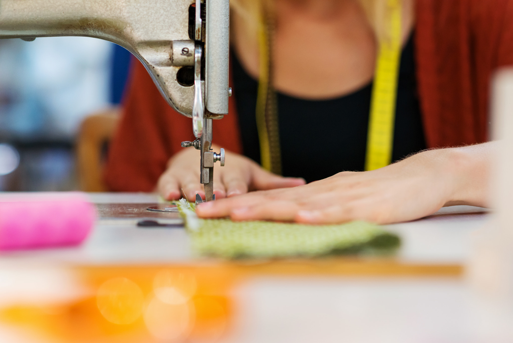 Hands of unrecognizable tailor woman working with sewing machine
