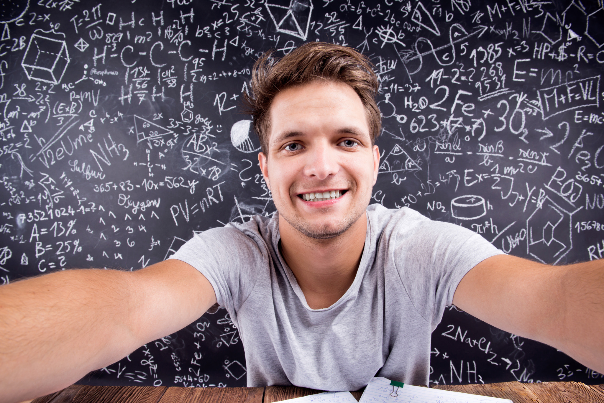 Hipster student doing taking selfie against a big blackboard