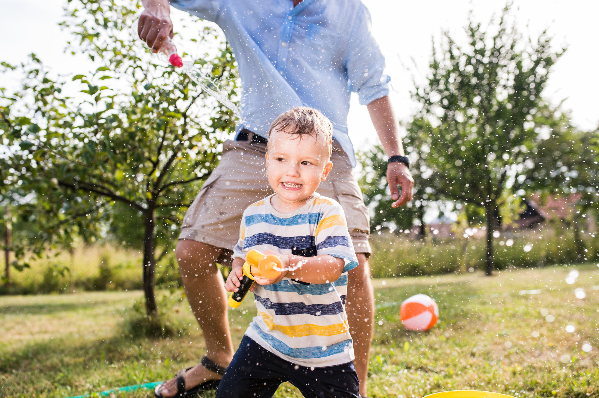 Nikon D4S + Sigma 35mm F1.4 DG HSM Art sample photo. Little boy with father playing with water guns, splashing photography
