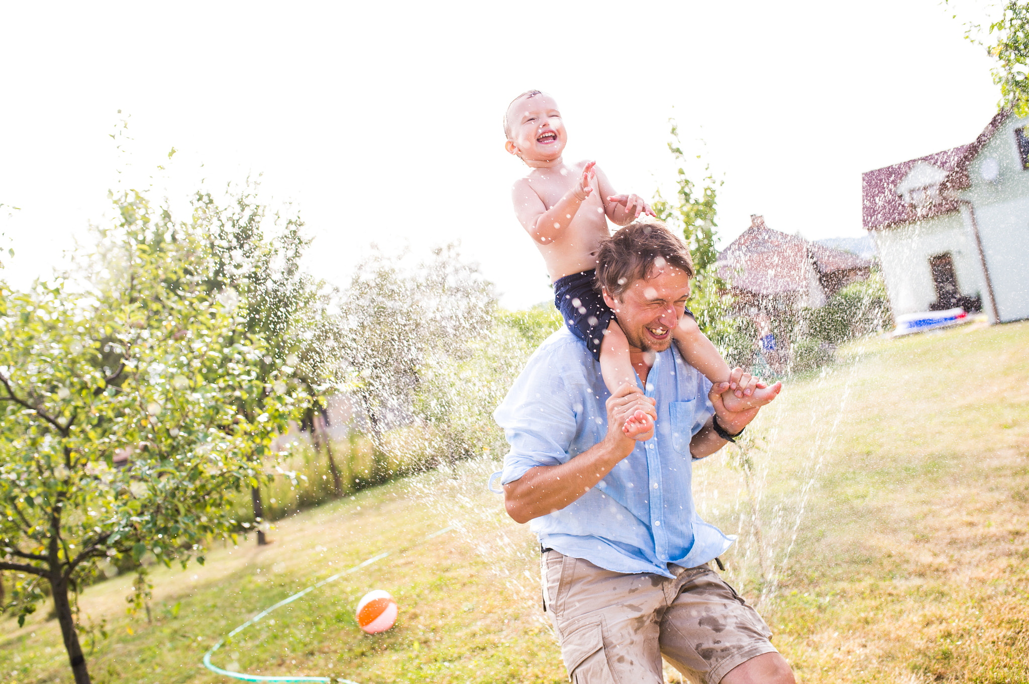 Nikon D4S + Sigma 35mm F1.4 DG HSM Art sample photo. Little boy with his father at the sprinkler, summer photography
