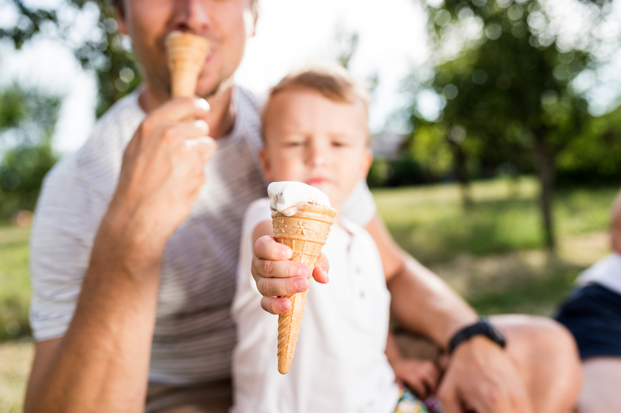Nikon D4S + Sigma 35mm F1.4 DG HSM Art sample photo. Father and son eating ice cream, sunny summer garden photography