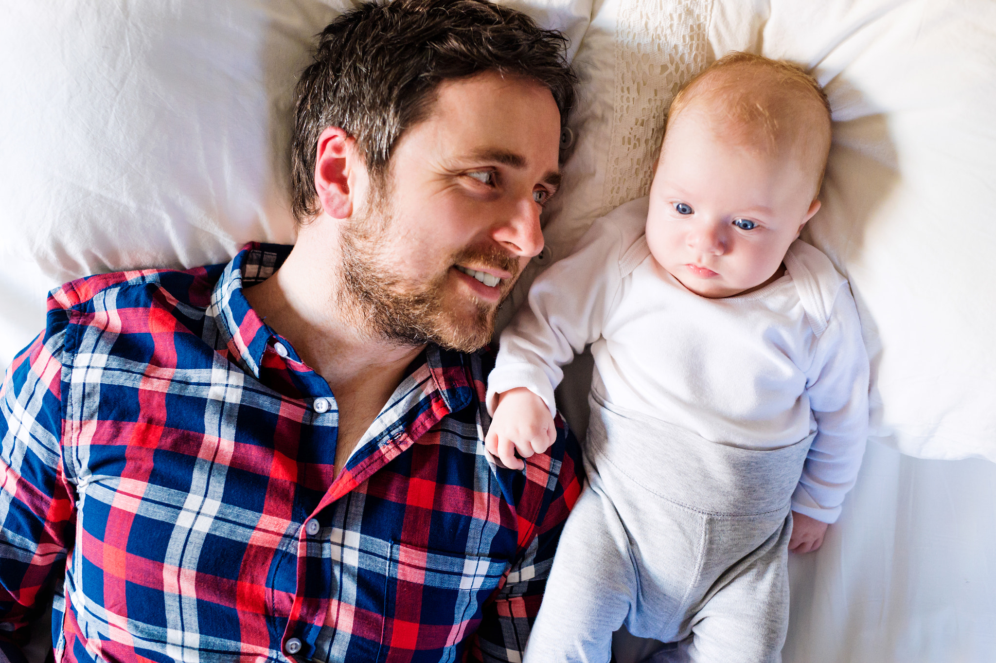 Nikon D4S + Sigma 50mm F1.4 DG HSM Art sample photo. Baby boy lying on bed, next to his father photography