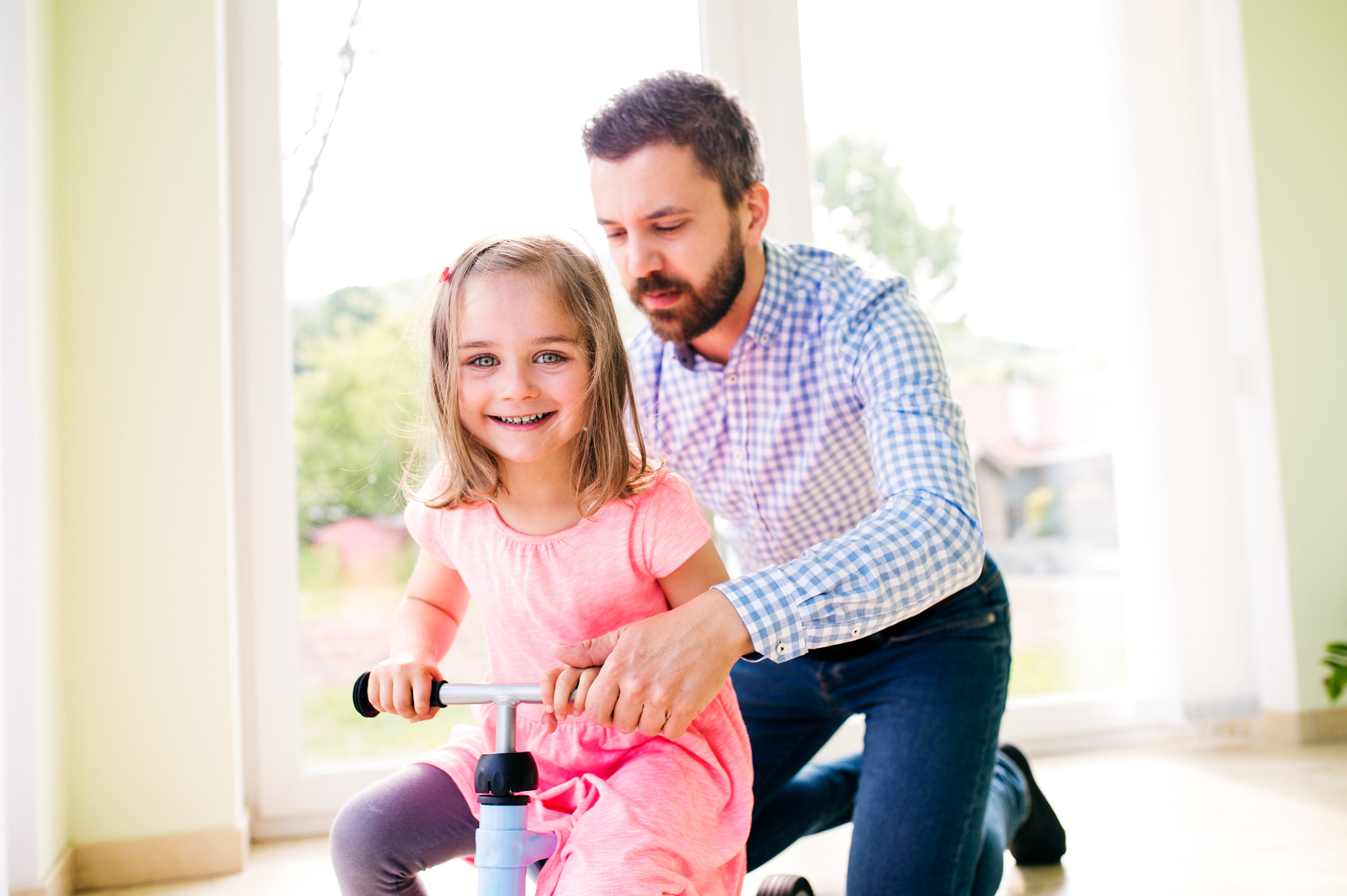 Nikon D4S + Sigma 35mm F1.4 DG HSM Art sample photo. Father and daughter playing together, riding a bike indoors photography