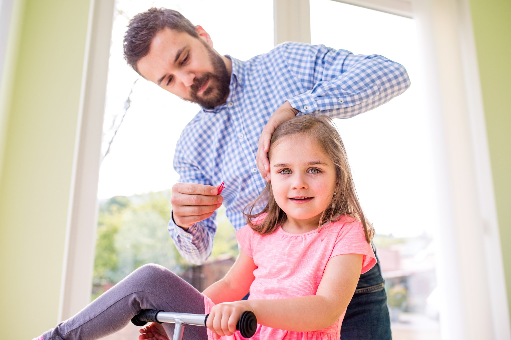 Nikon D4S + Sigma 35mm F1.4 DG HSM Art sample photo. Father with daughter, styling her hair, riding bicycle indoors photography