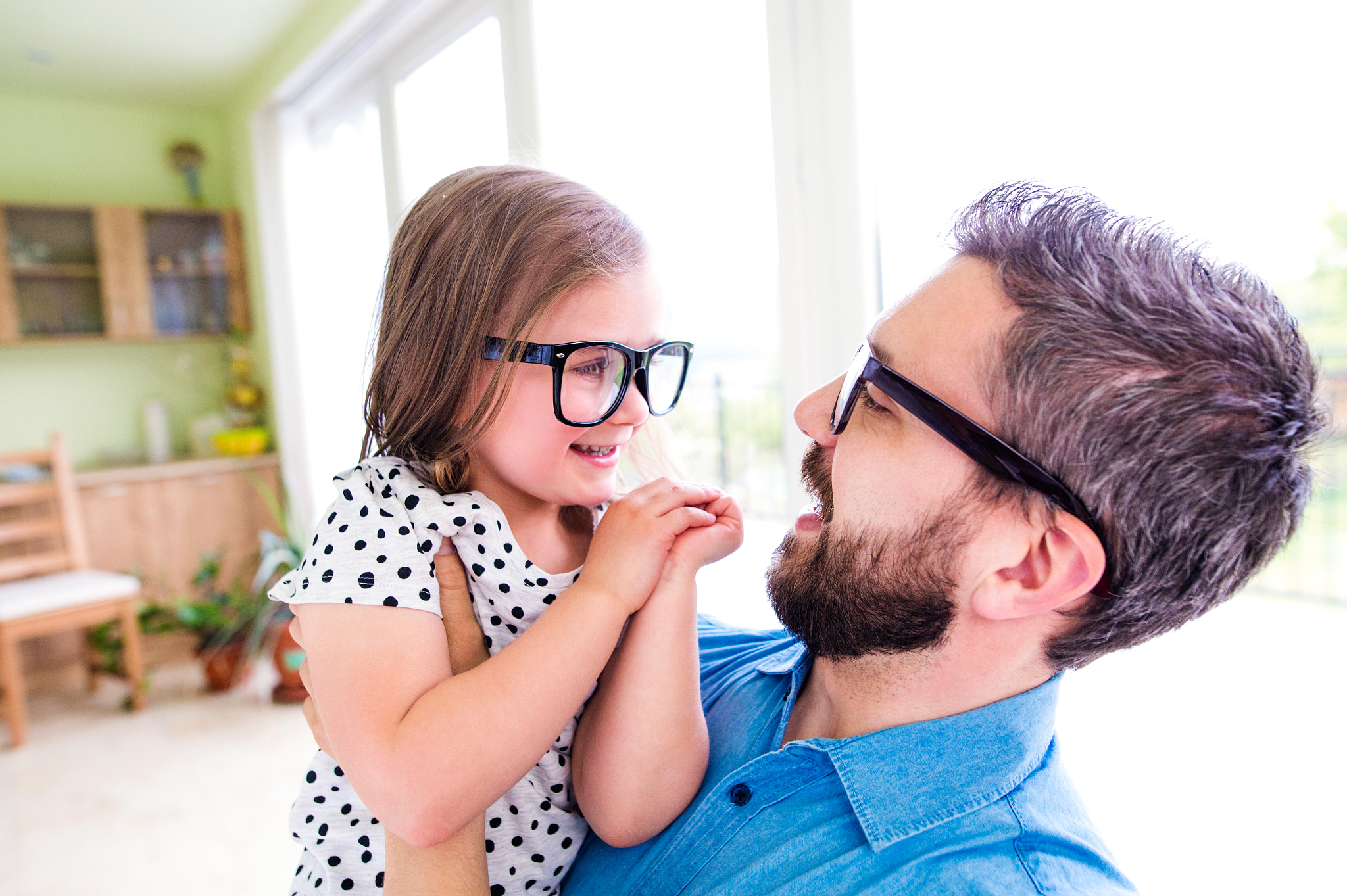 Father with his little daughter in black hipster eyeglasses