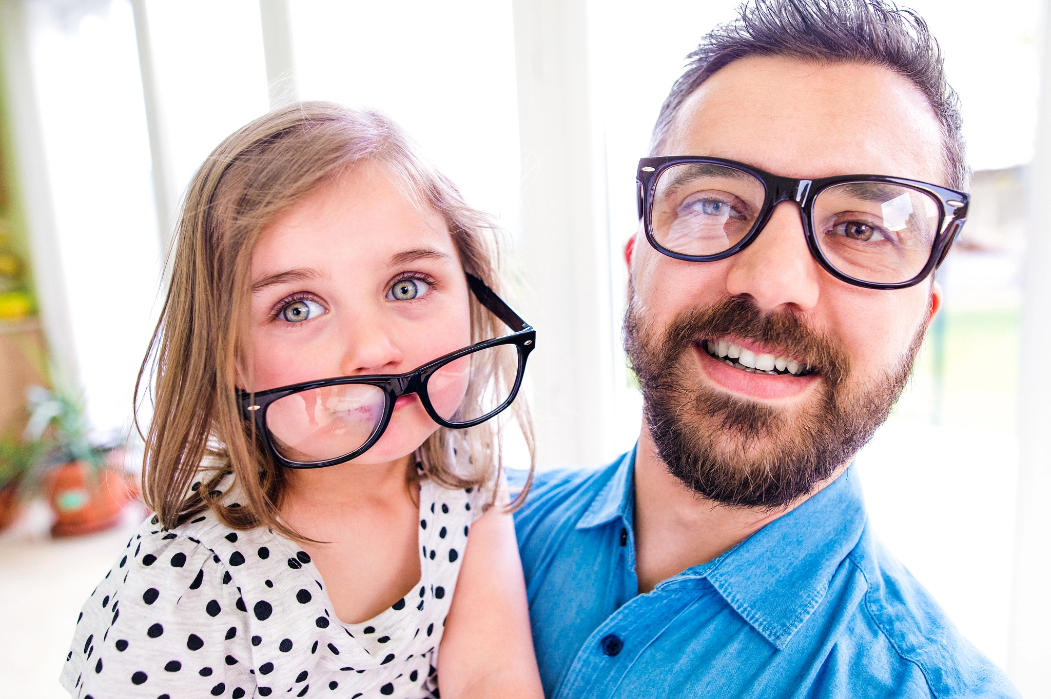 Father with his little daughter in black hipster eyeglasses