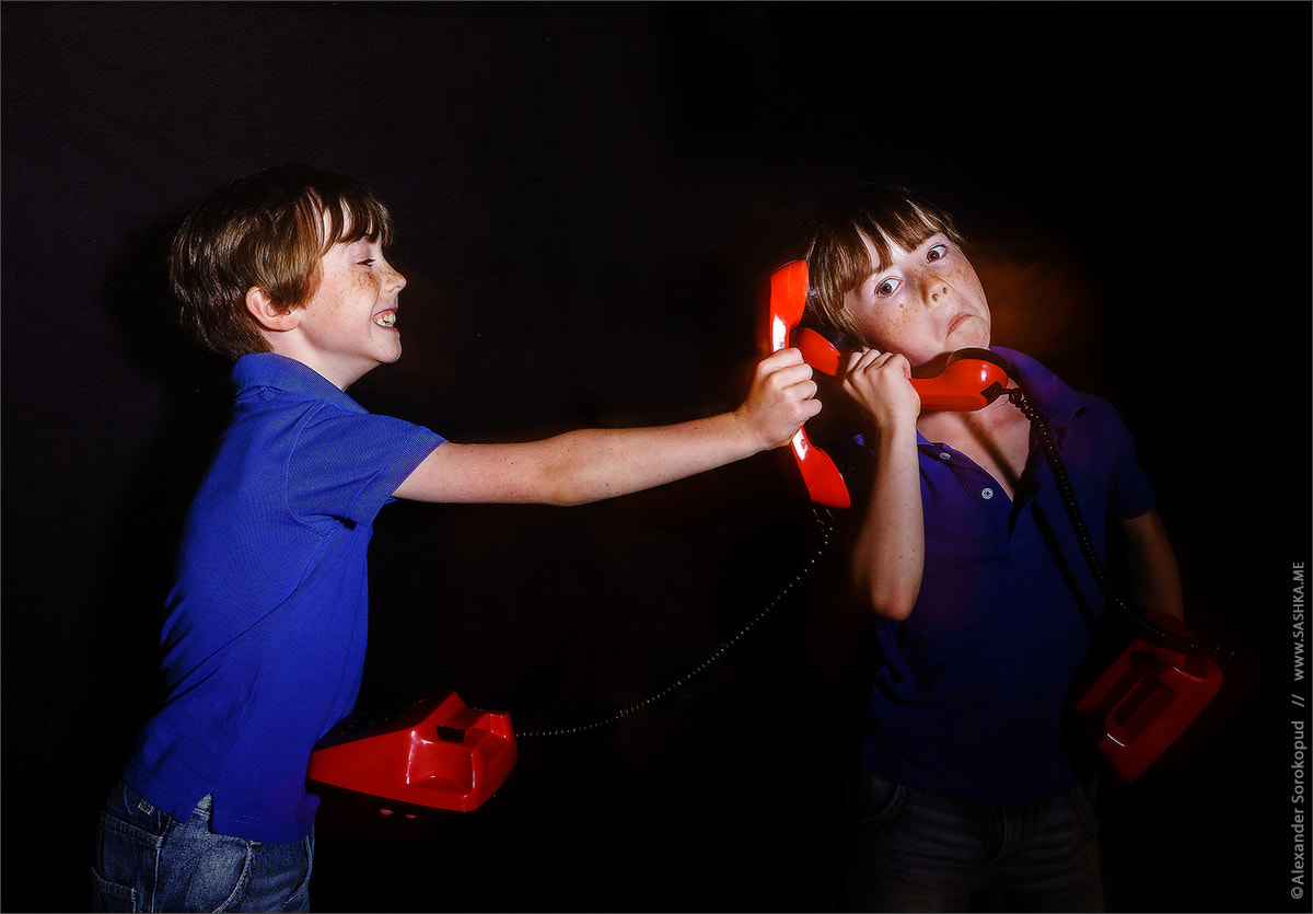 Sony a99 II sample photo. Freckled boy speaking old-style red phone, double-exposition photography