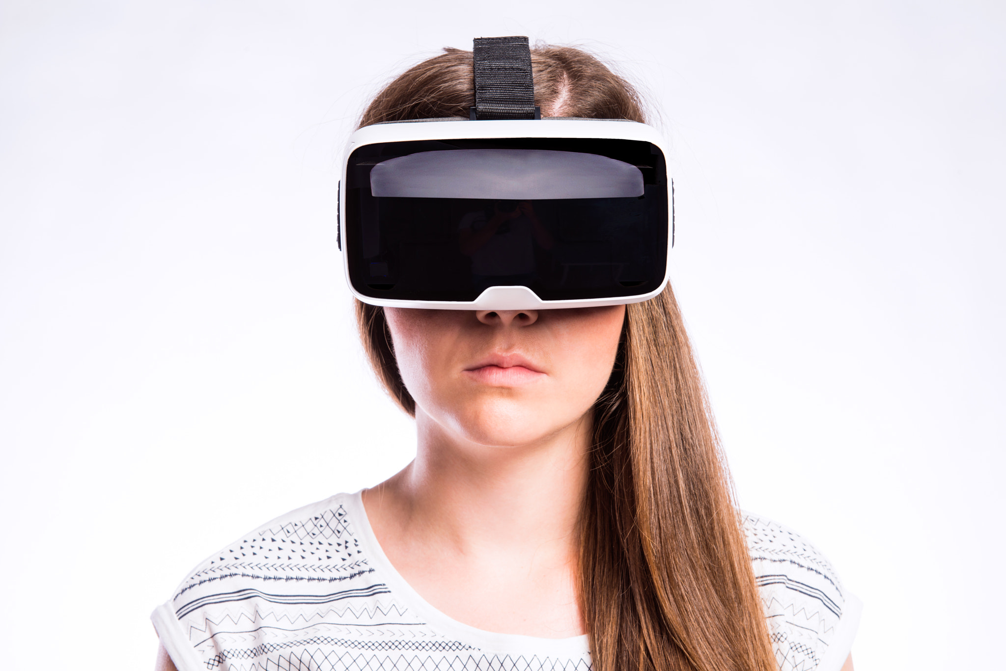 Woman with virtual reality goggles. Studio shot, gray background