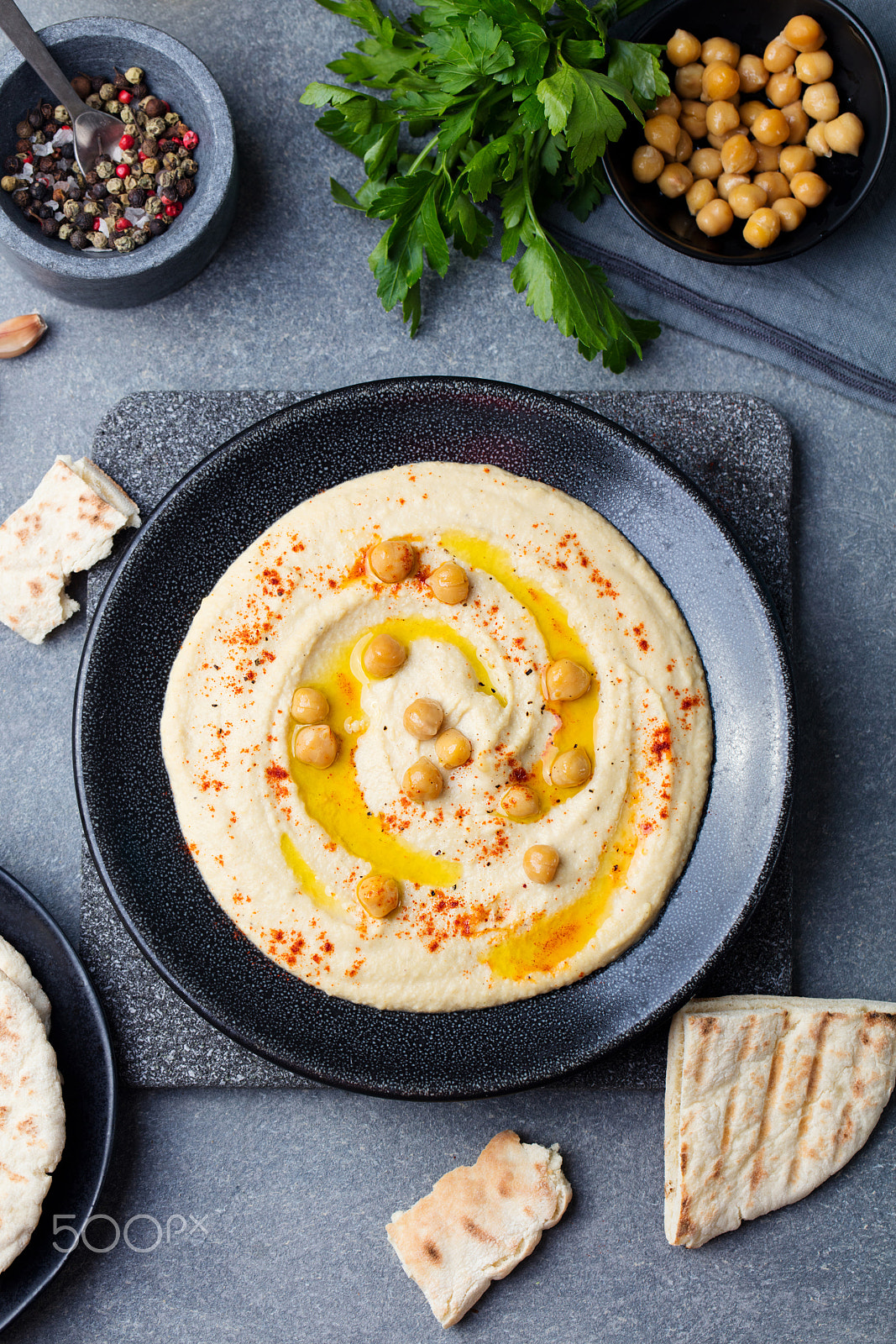 Canon EOS 5DS + Canon EF 100mm F2.8L Macro IS USM sample photo. Hummus, chickpea dip, with spices and pita, flat bread in a black plate. top view photography