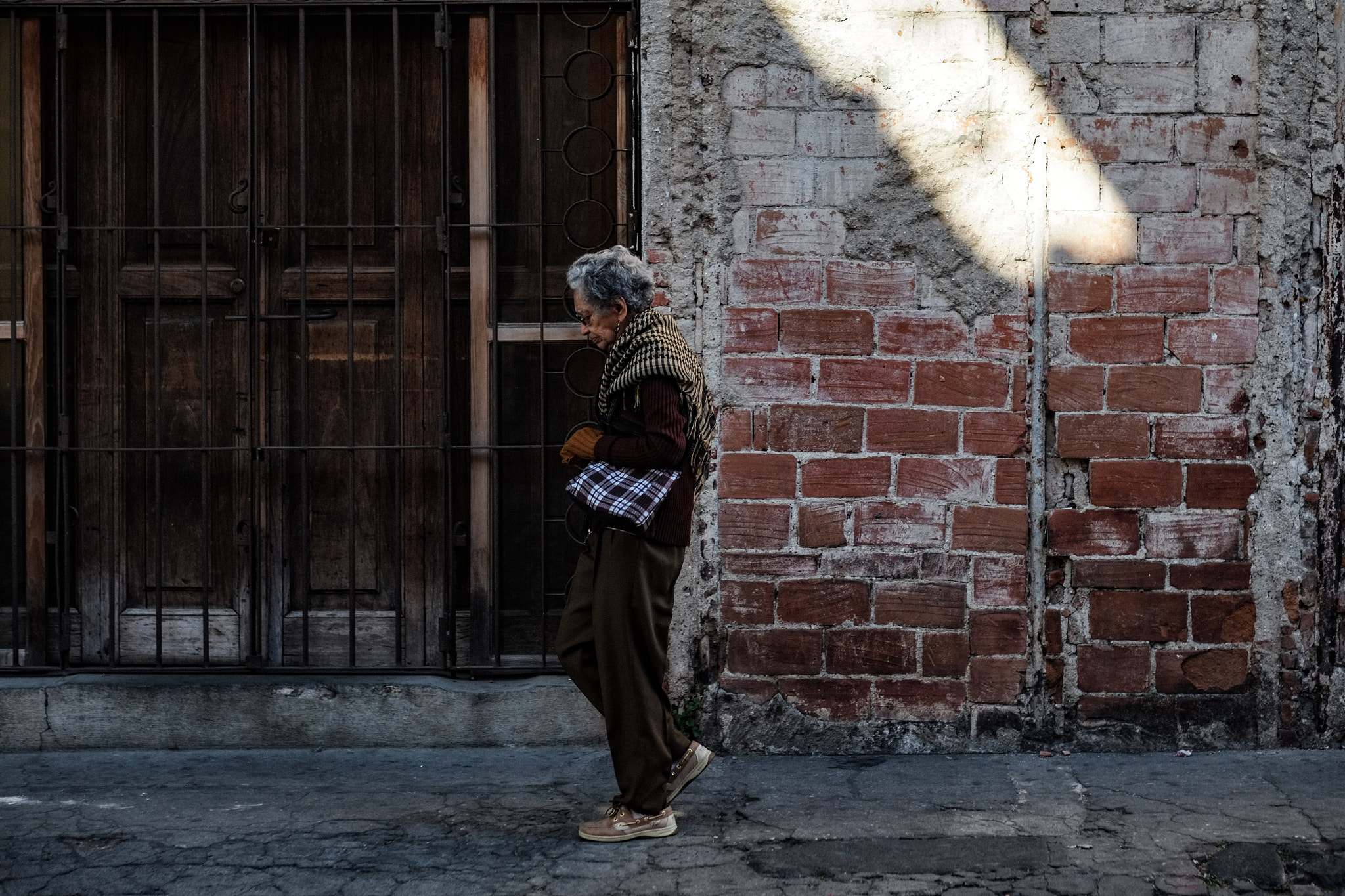 Fujifilm X-Pro1 + Fujifilm XF 56mm F1.2 R sample photo. Brown lady walking photography