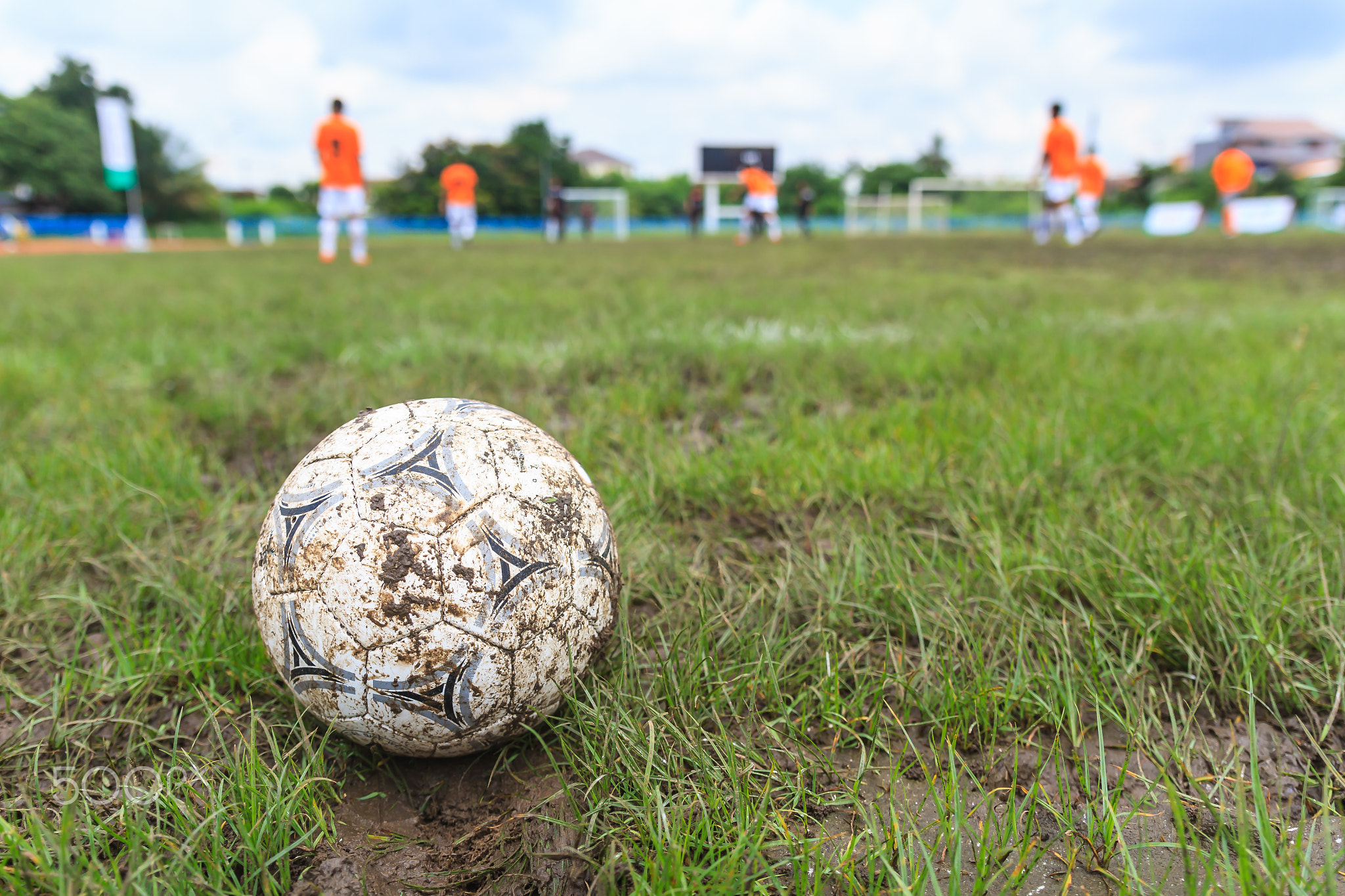 Muddy soccer ball on a football field