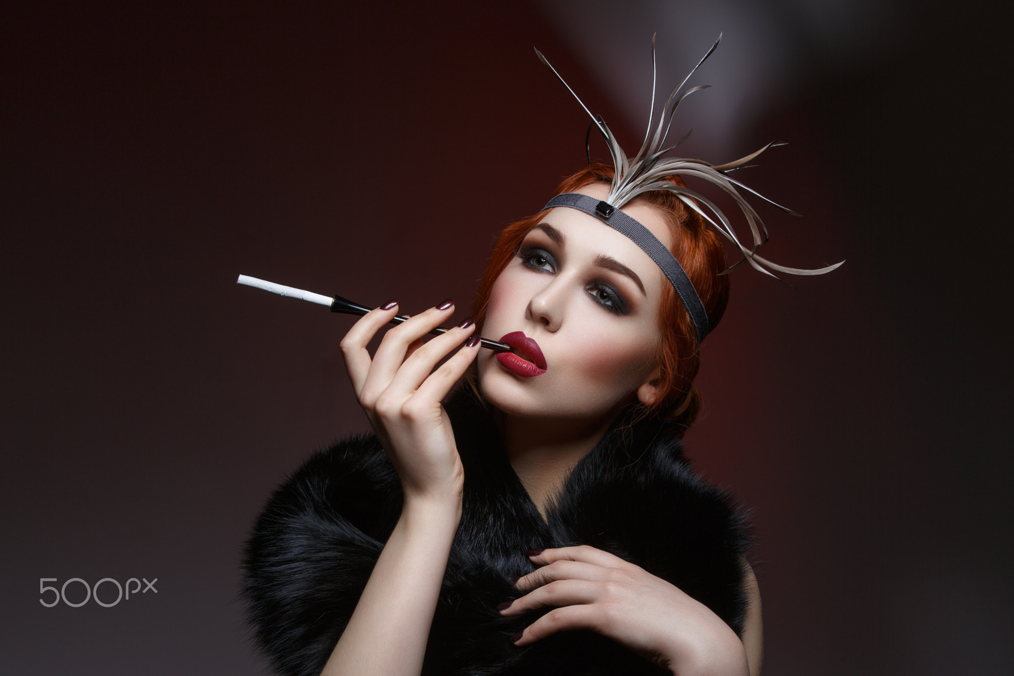 Beautiful girl with smoky eyes and red lips holding cigarette