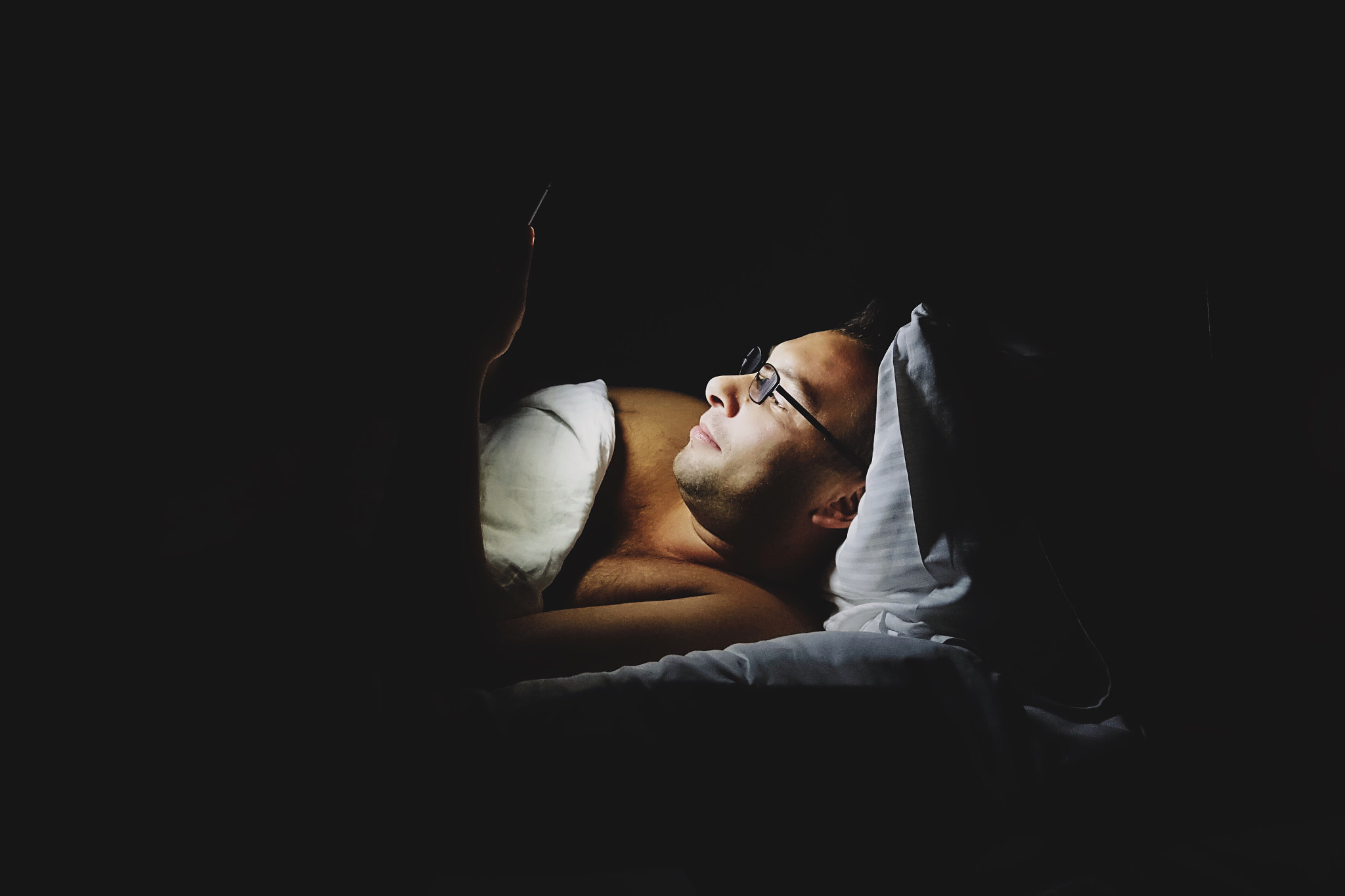 Sony Cyber-shot DSC-RX100 IV sample photo. Man using his mobile phone in bed during nighttime ... photography