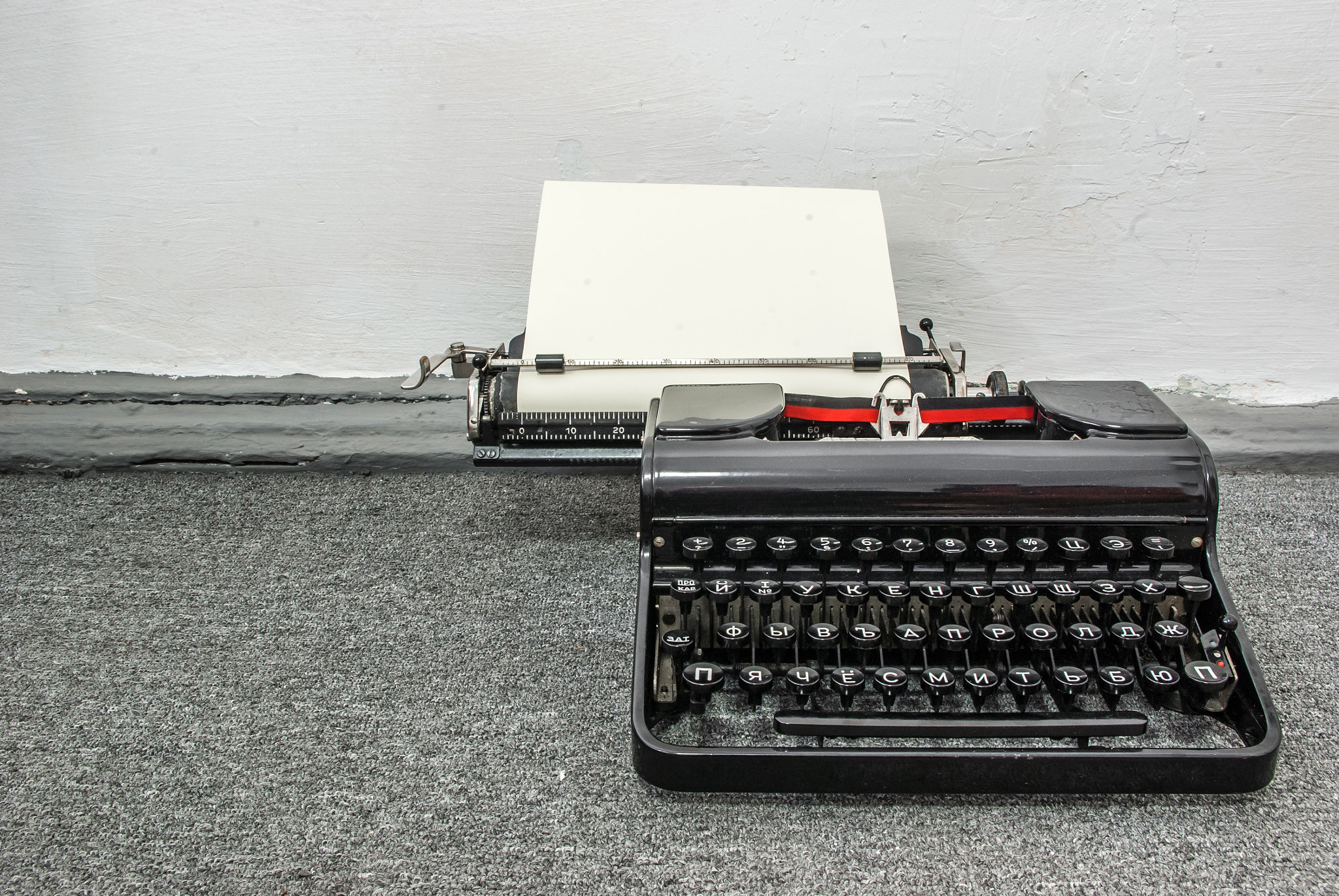 Old typerwiter with cyrillic letters on grey floor background