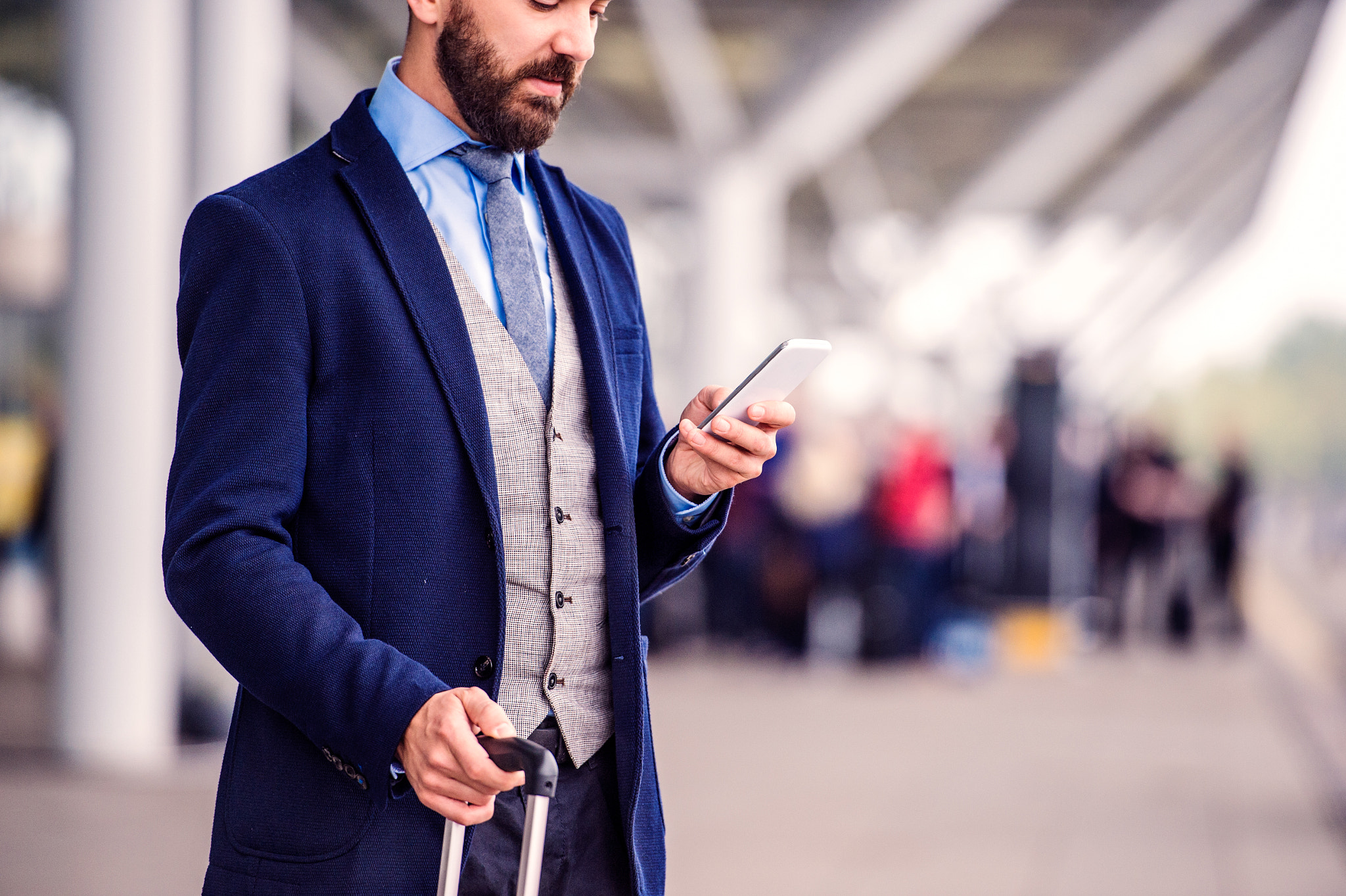 Hipster businessman with smart phone waiting at the airport