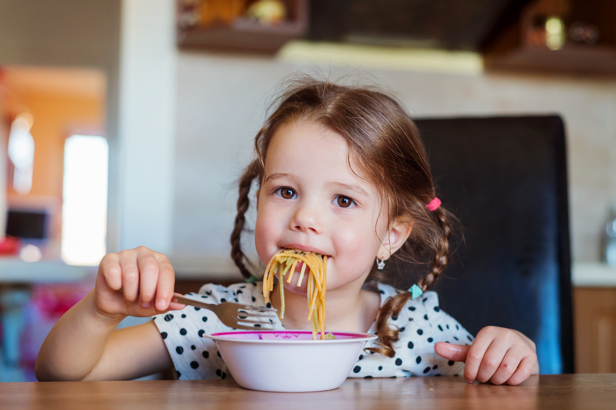 Nikon D4S + Nikon AF Nikkor 50mm F1.8D sample photo. Little girl in the kitchen smiling, eating spaghetti photography