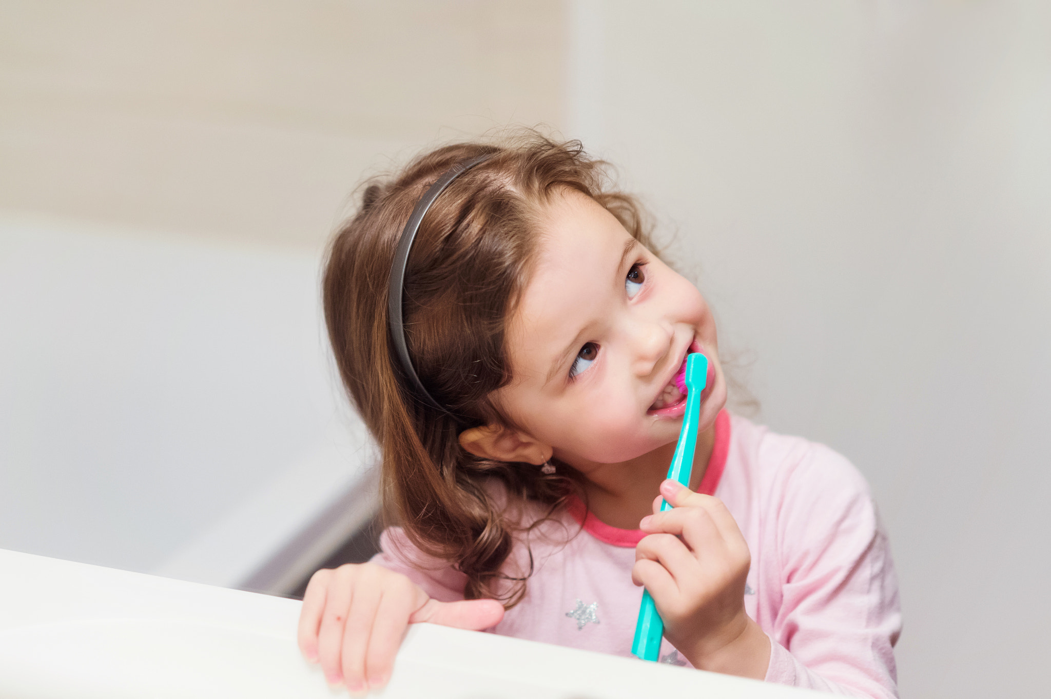 Nikon D4S + Nikon AF Nikkor 85mm F1.8D sample photo. Little girl in pink pyjamas in bathroom brushing teeth photography