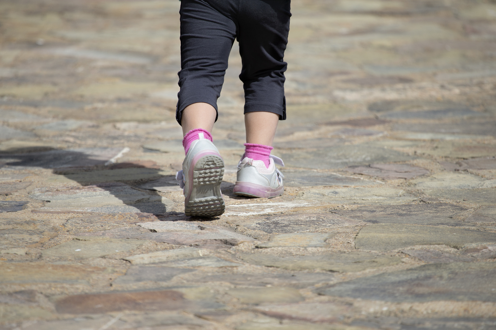 Canon EF 100-400mm F4.5-5.6L IS USM sample photo. Unrecognizable kid walking away on stone path photography