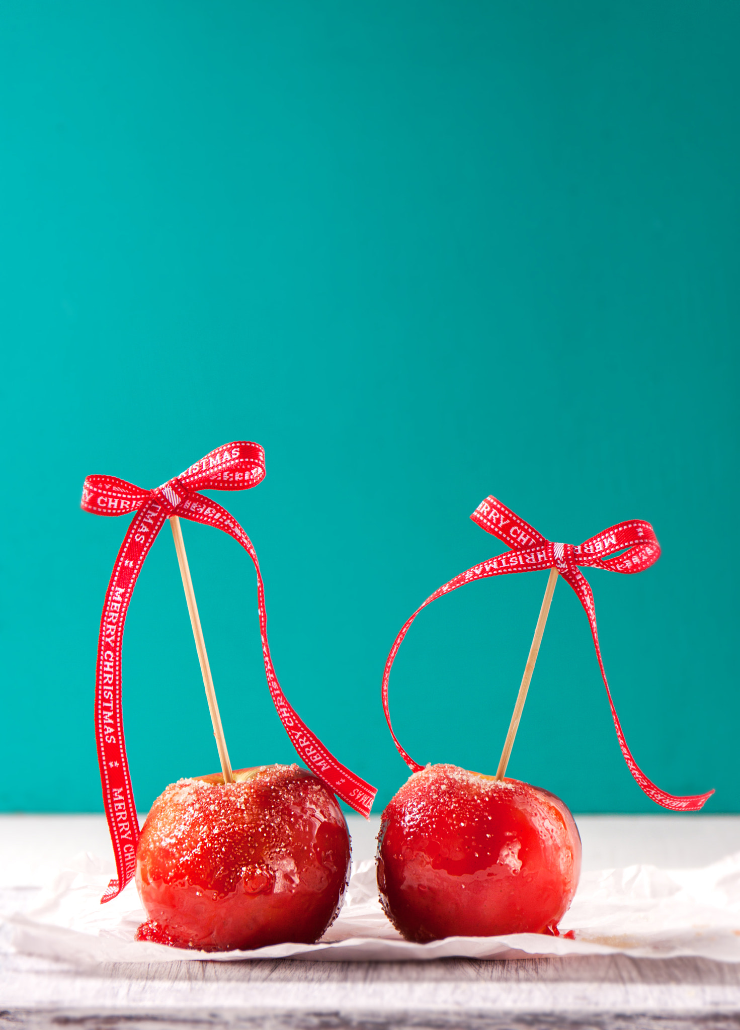 Canon EOS 50D + Canon EF 24-70mm F4L IS USM sample photo. Homemade candied apples with a red bow on a wooden background, copy space photography