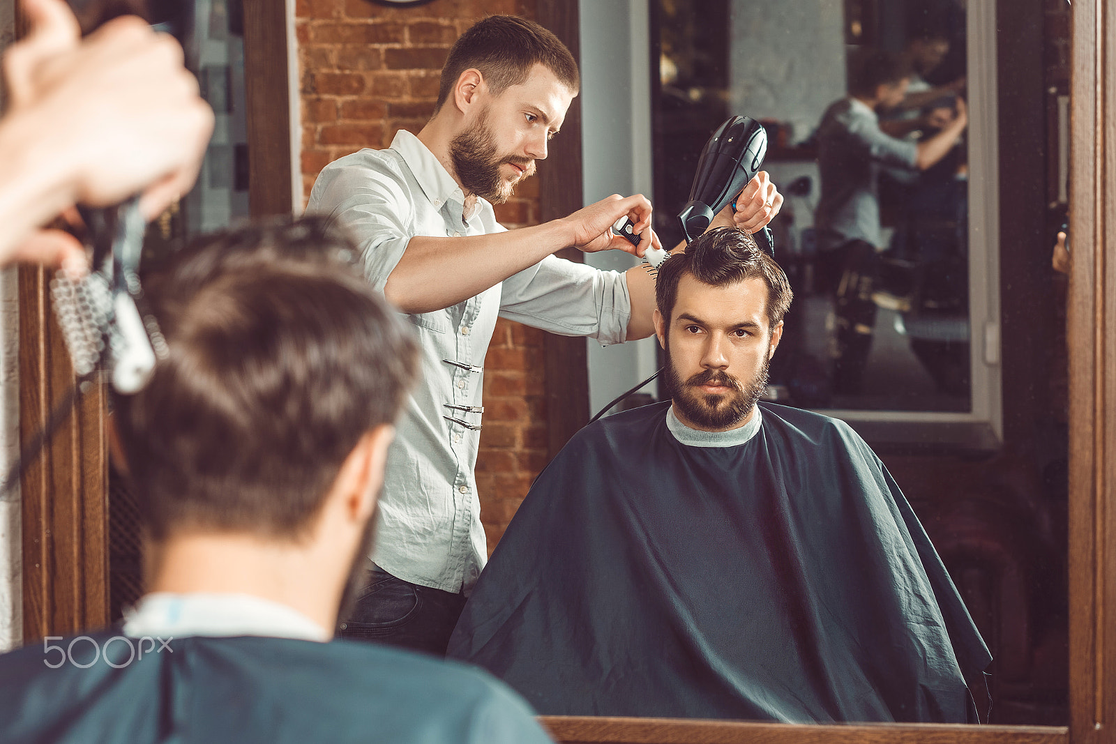 Canon EF 100mm F2.0 USM sample photo. Young handsome barber making haircut of attractive man in barbershop photography