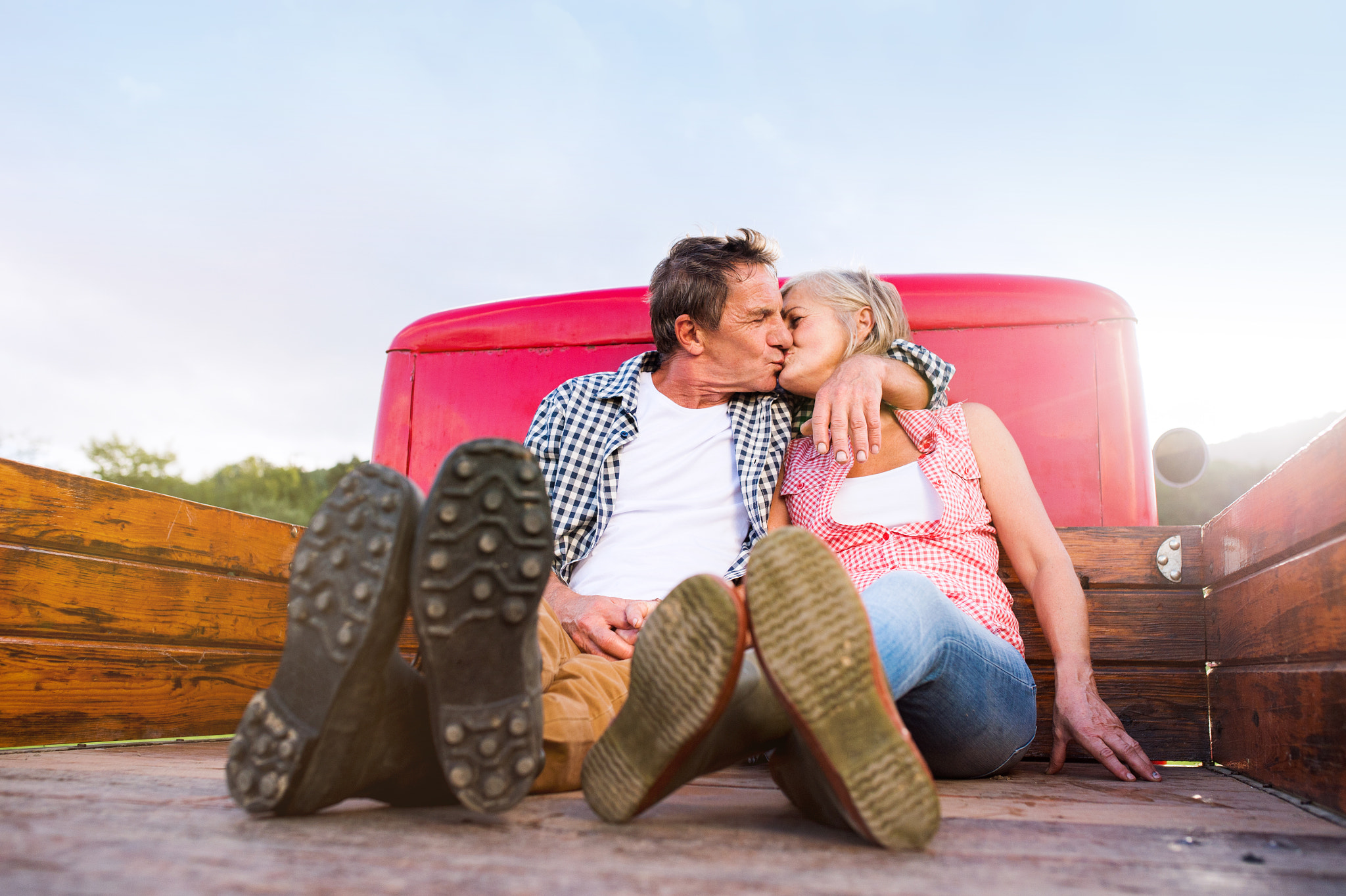 Nikon D4S + Sigma 35mm F1.4 DG HSM Art sample photo. Senior couple sitting in back of red pickup truck photography