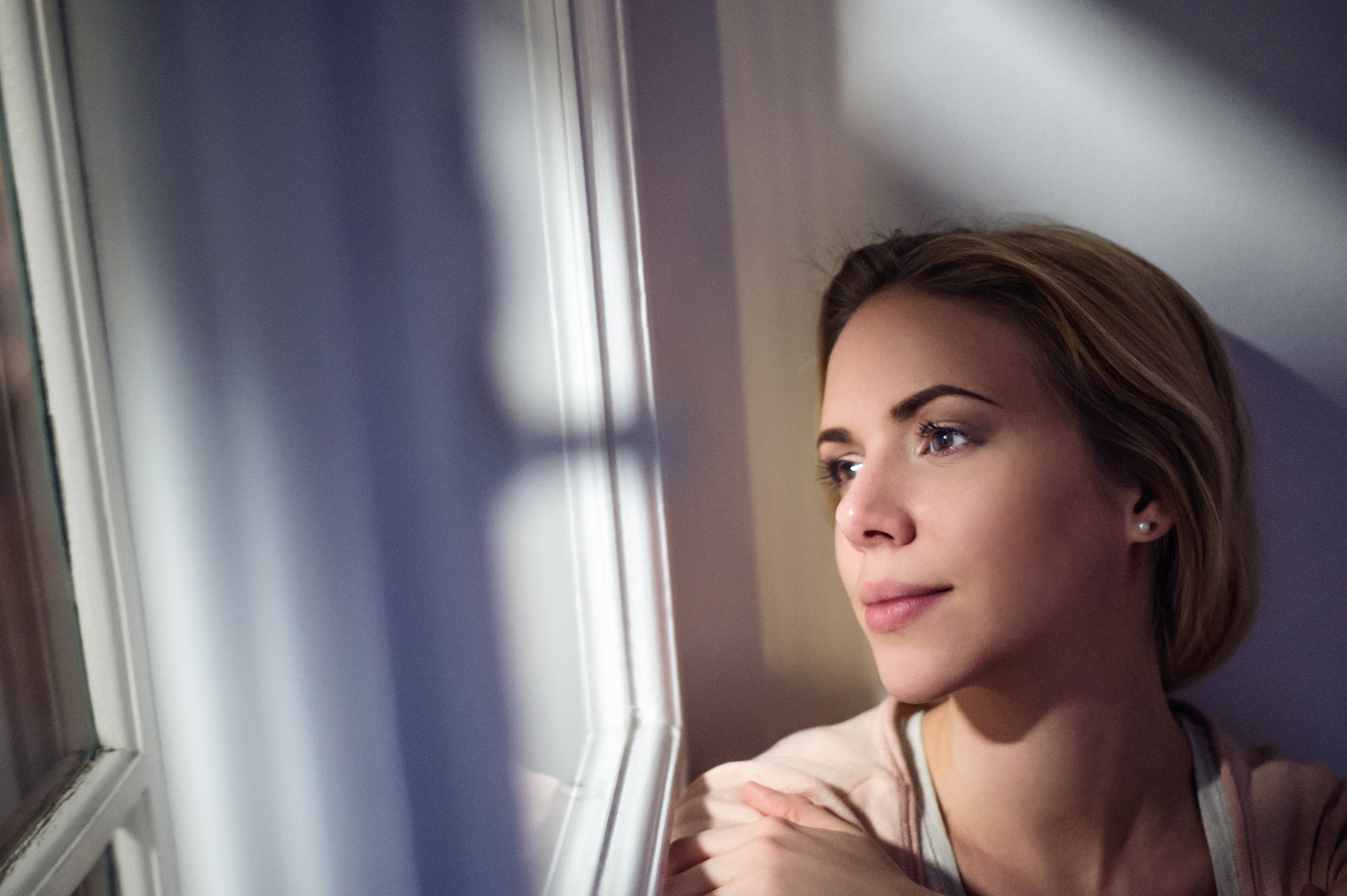 Nikon D4S sample photo. Woman sitting on window sill, looking out of window photography