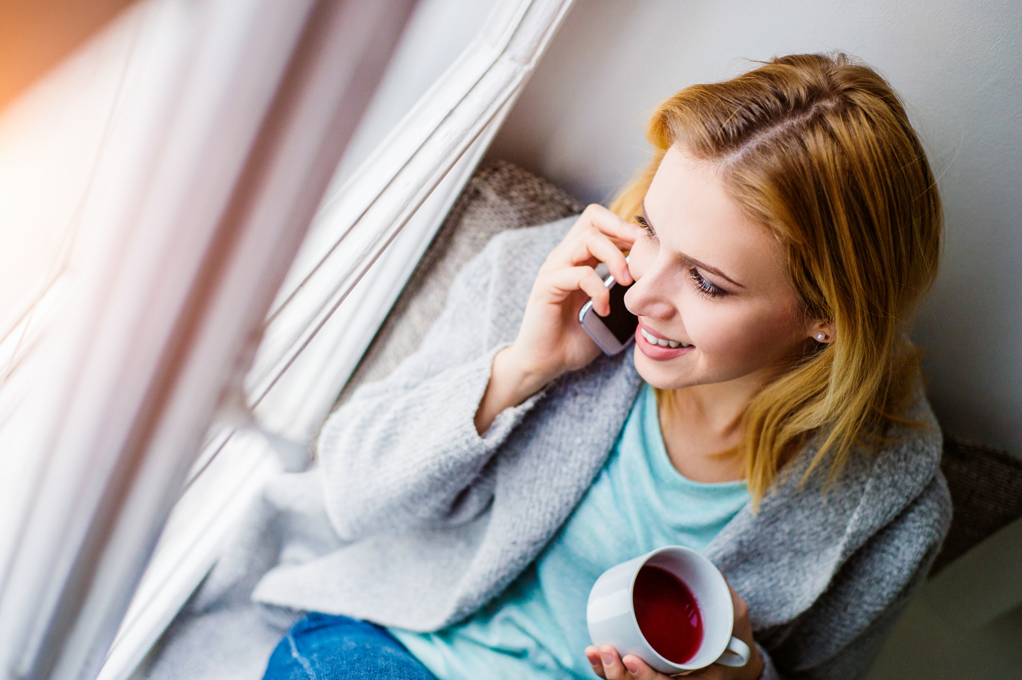 Nikon D4S sample photo. Woman on window sill with smartphone making phone call photography