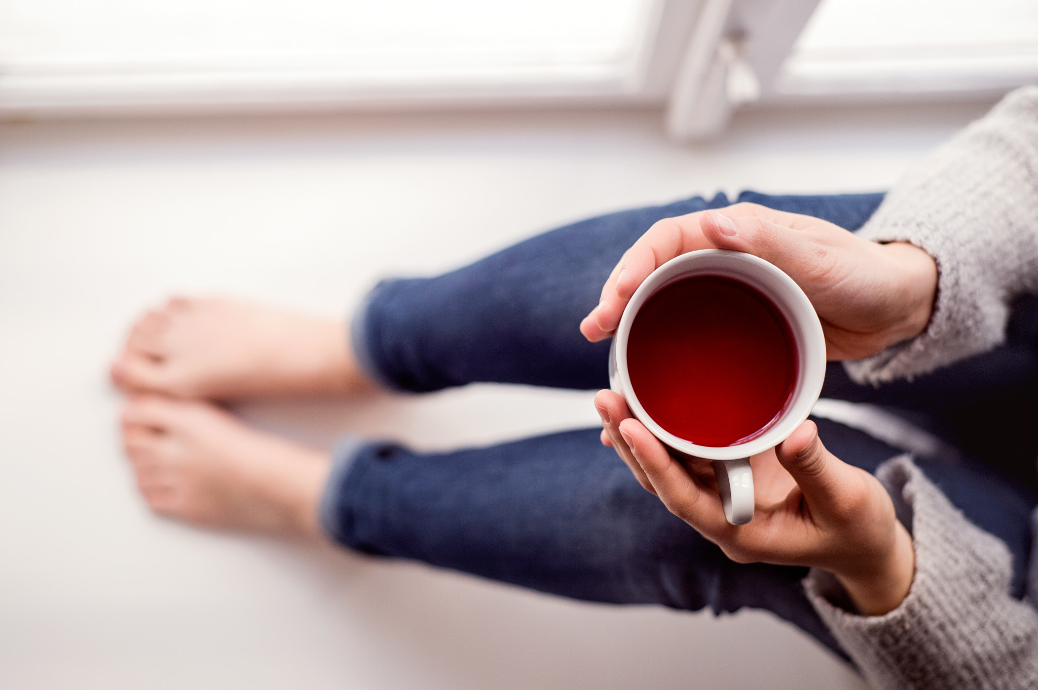 Nikon D4S sample photo. Woman on window sill holding a cup of tea photography