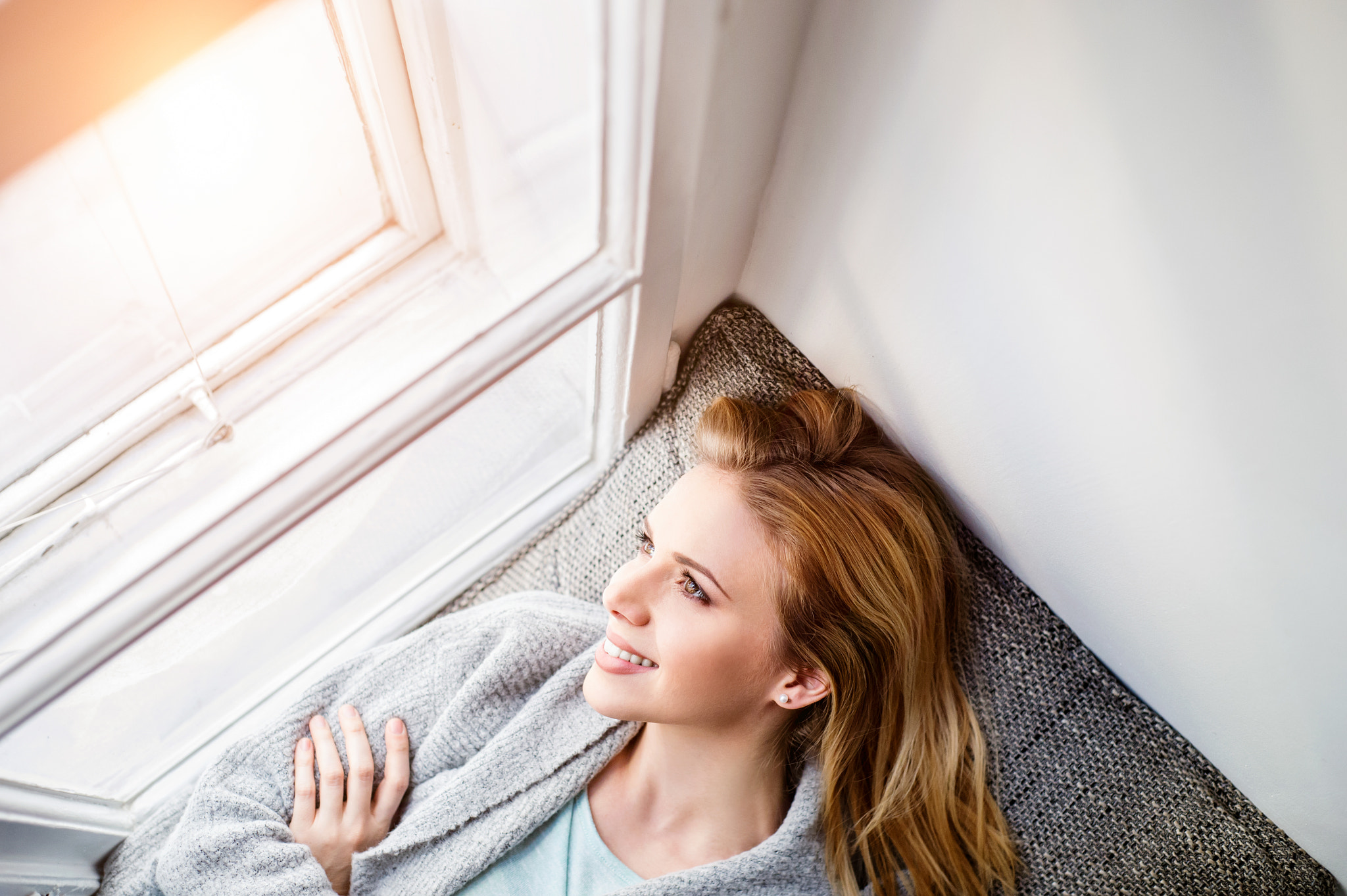 Nikon D4S sample photo. Woman lying on window sill, looking out of window photography