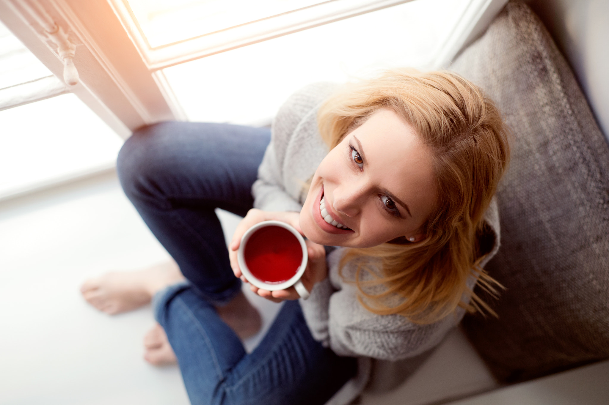 Nikon D4S + Nikon AF Nikkor 50mm F1.8D sample photo. Woman on window sill holding a cup of tea photography