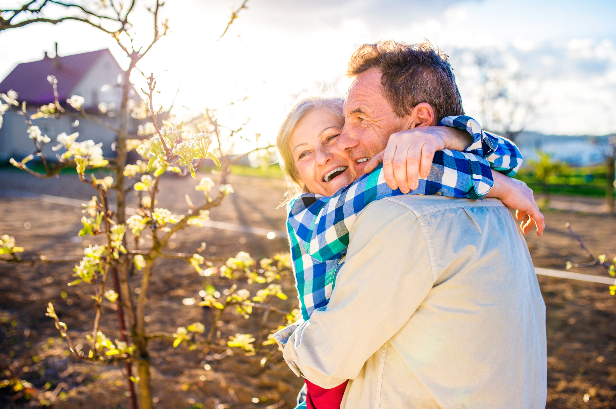 Nikon D4S + Sigma 35mm F1.4 DG HSM Art sample photo. Senior couple hugging in spring garden, sunny nature photography