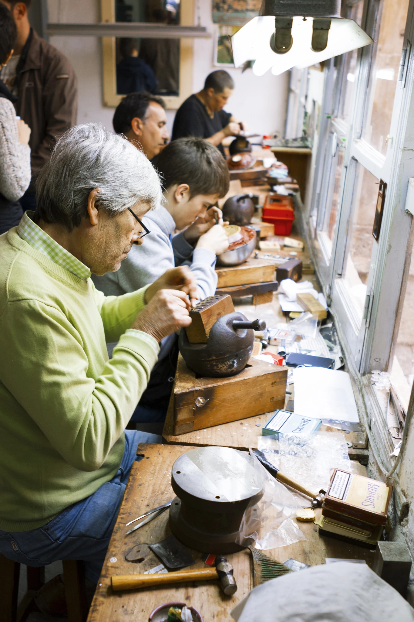 Artisan jewelers creating hand made jewelry items in a workshop.