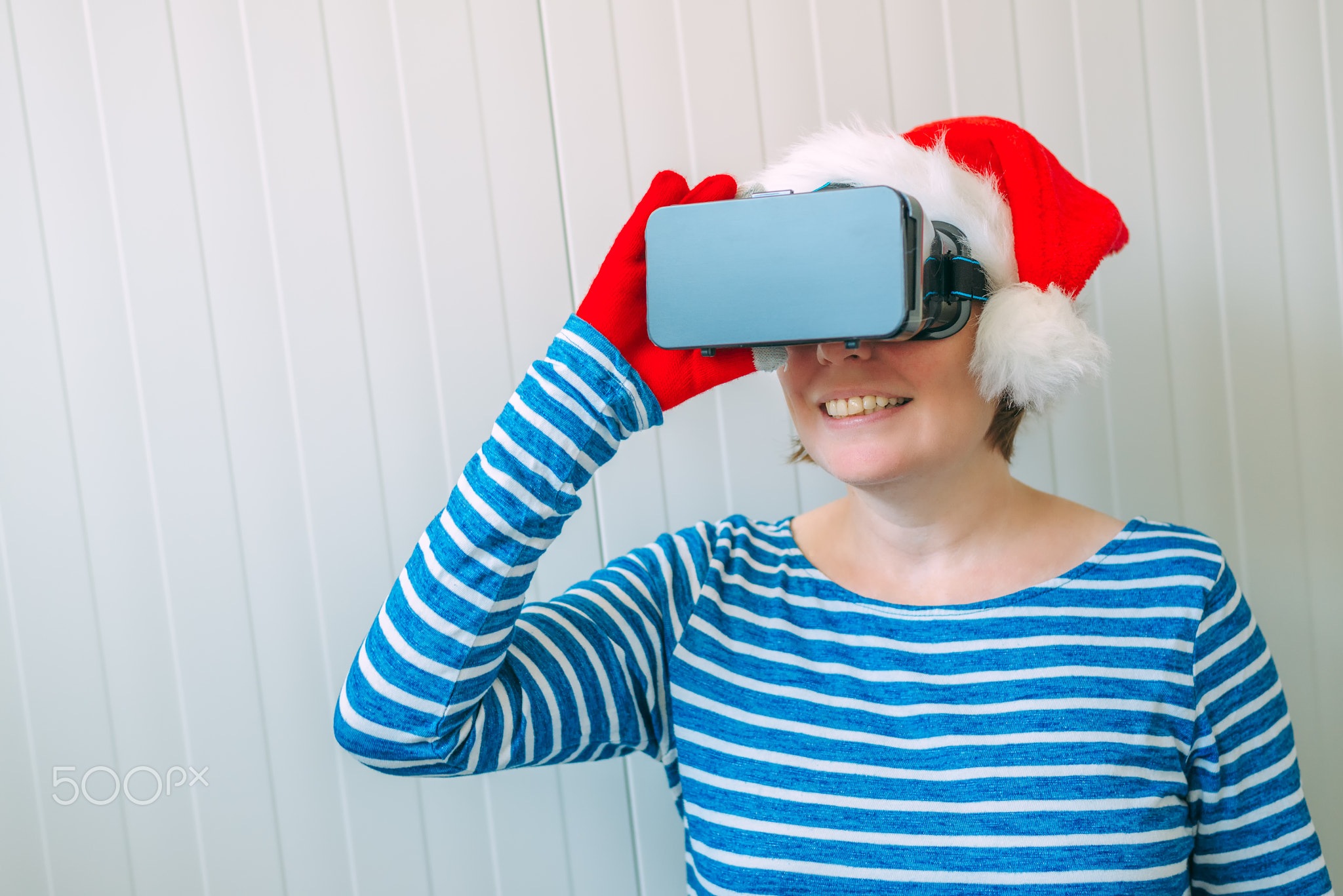 Woman with Christmas Santa Claus hat and VR headset