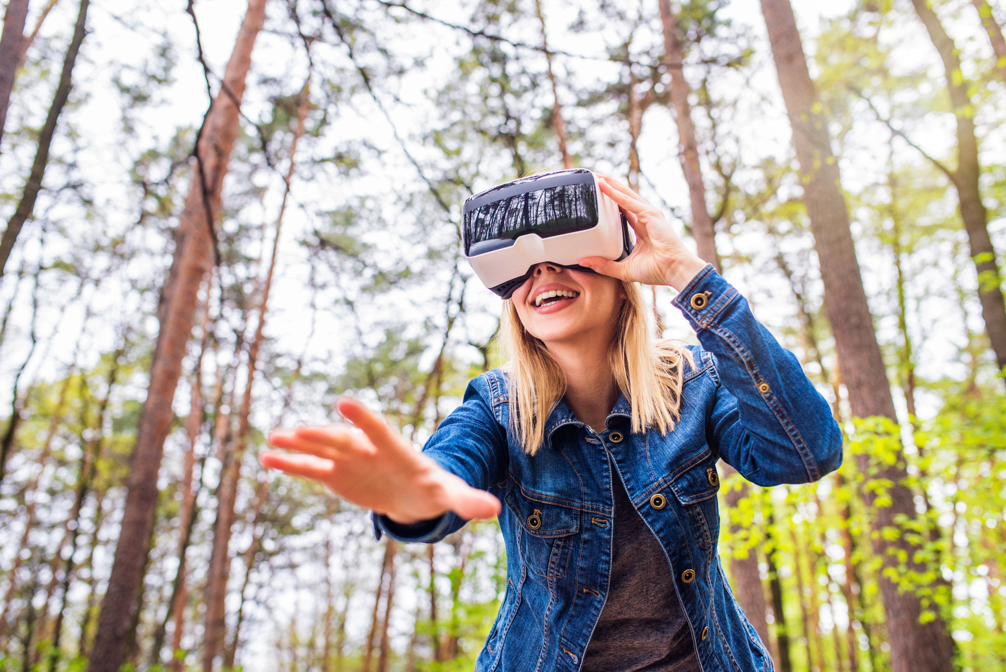 Woman wearing virtual reality goggles outside in spring nature