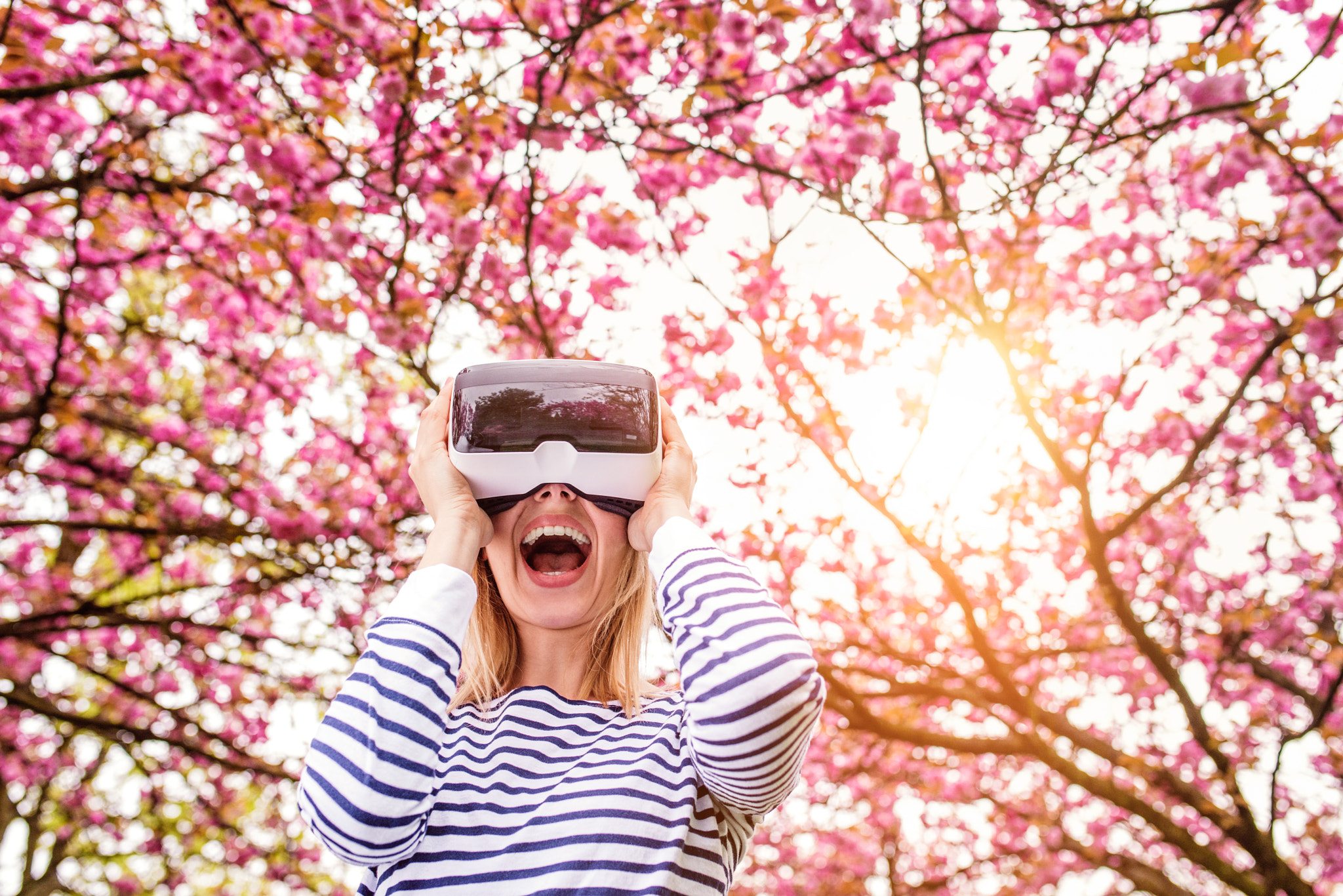 Woman wearing virtual reality goggles outside in spring nature