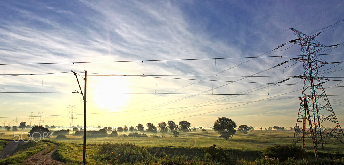 Canon EOS 50D sample photo. Sun rising behind electricity pylon and railroad tracks photography