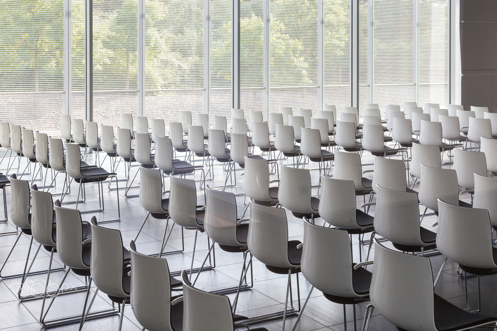 Empty white chairs in contemporary conference hall with