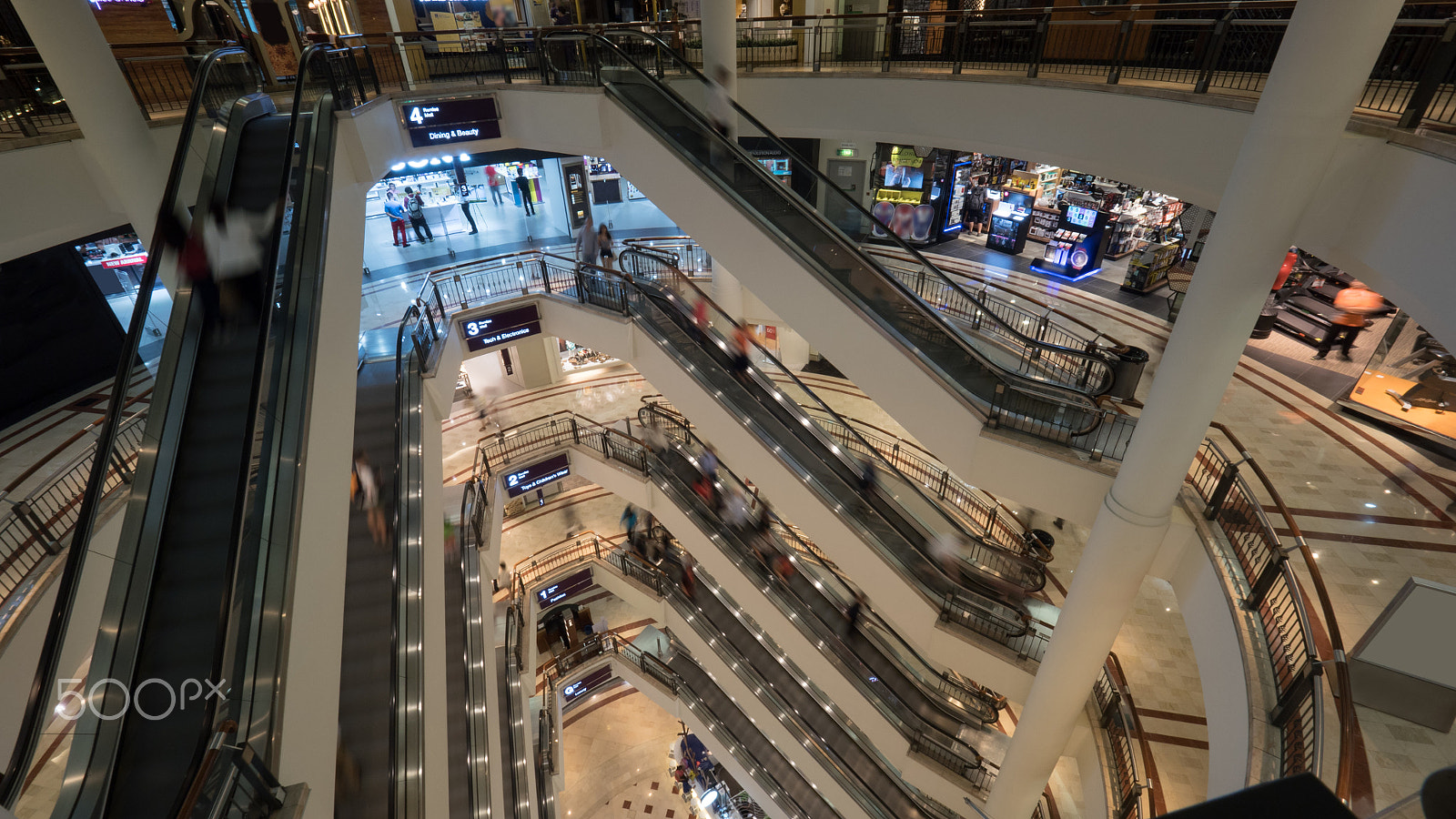 Panasonic Lumix DMC-GH4 + Olympus M.Zuiko Digital ED 7-14mm F2.8 PRO sample photo. People on escalators in multistorey shopping mall photography