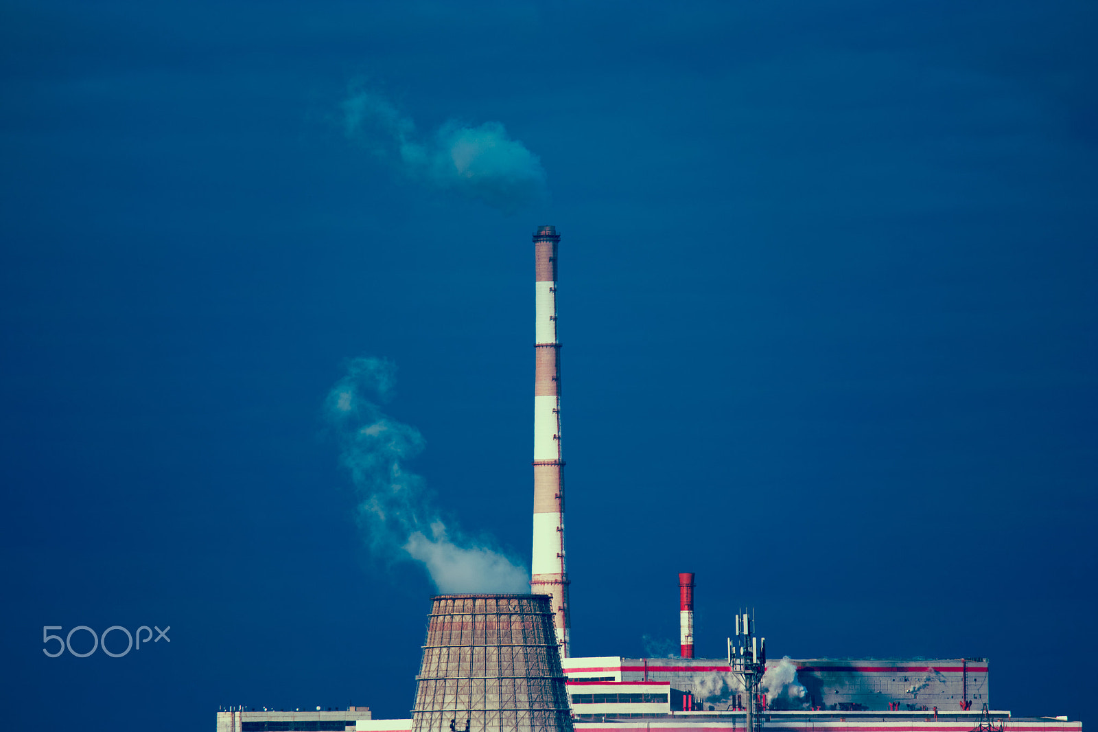 Samsung NX500 + Samsung NX 50-200mm F4-5.6 ED OIS sample photo. Power plant with two smoking chimney in front of blue sky. cooling tower of power-plant against... photography