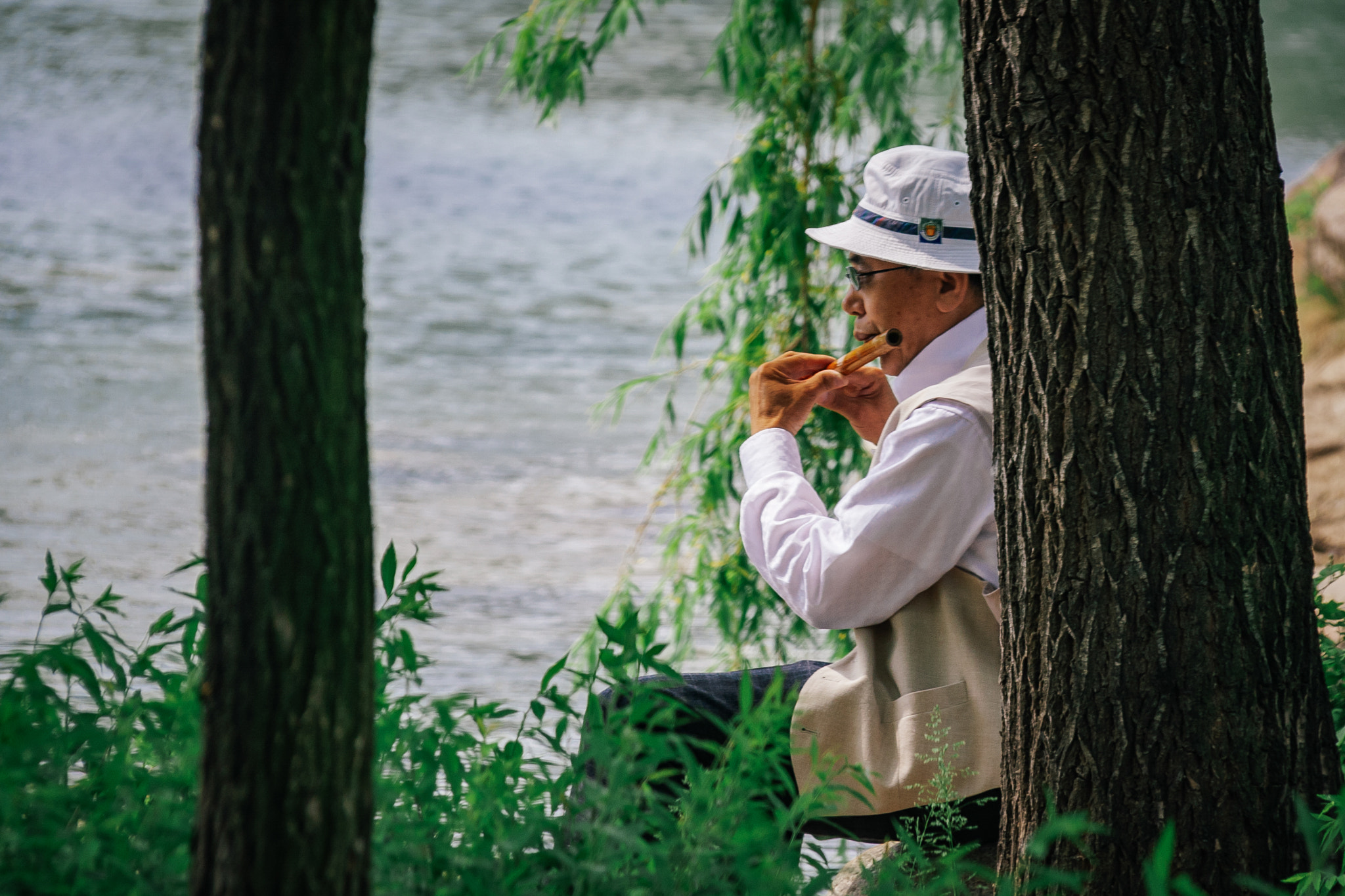 Canon EF-S 18-200mm F3.5-5.6 IS sample photo. On the shore playing the flute photography