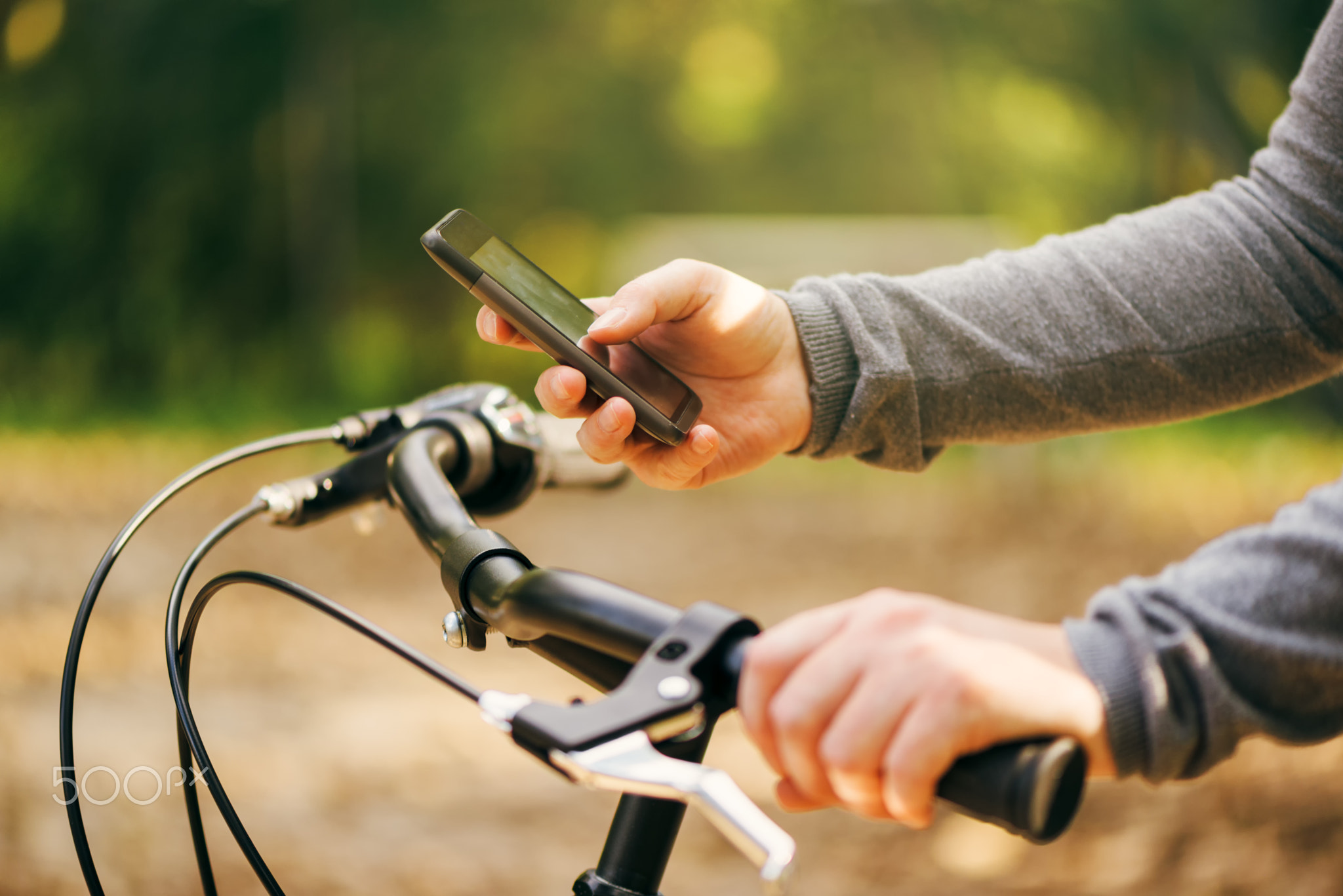 Woman typing text message during bicycle ride