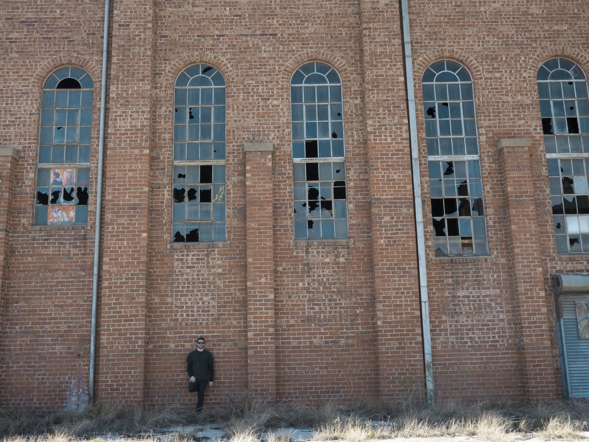 Panasonic Lumix DMC-GH4 + Panasonic Lumix G 20mm F1.7 ASPH sample photo. Brick wall with man posing photography