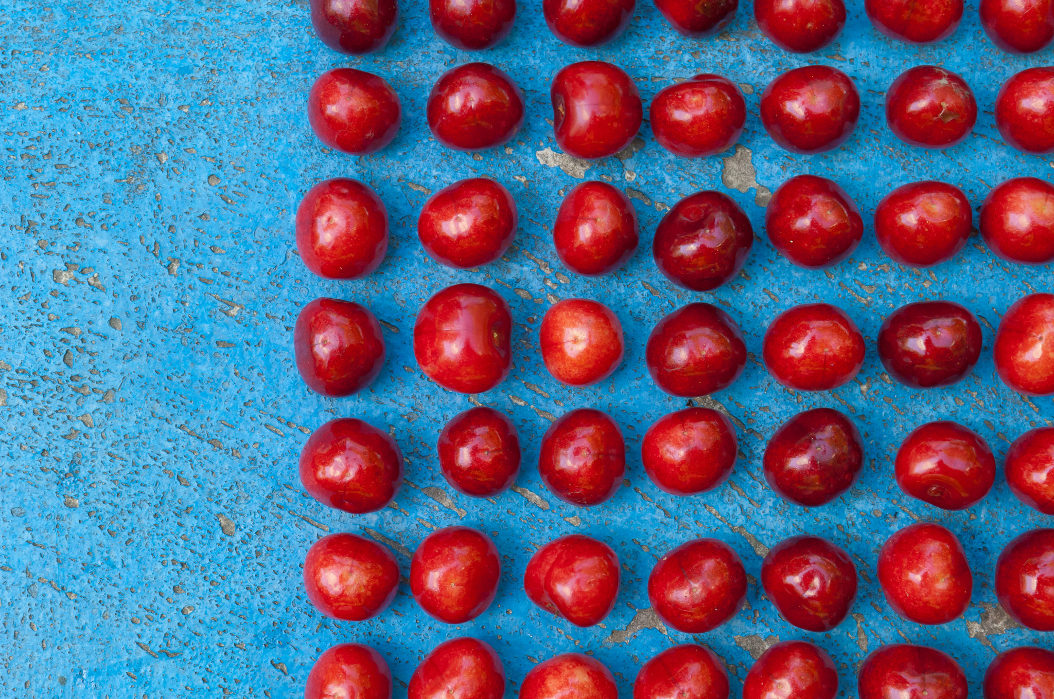 Nikon D2X + Nikon AF-S DX Nikkor 17-55mm F2.8G ED-IF sample photo. Arrangement of ripe cherries on blue textrured background photography