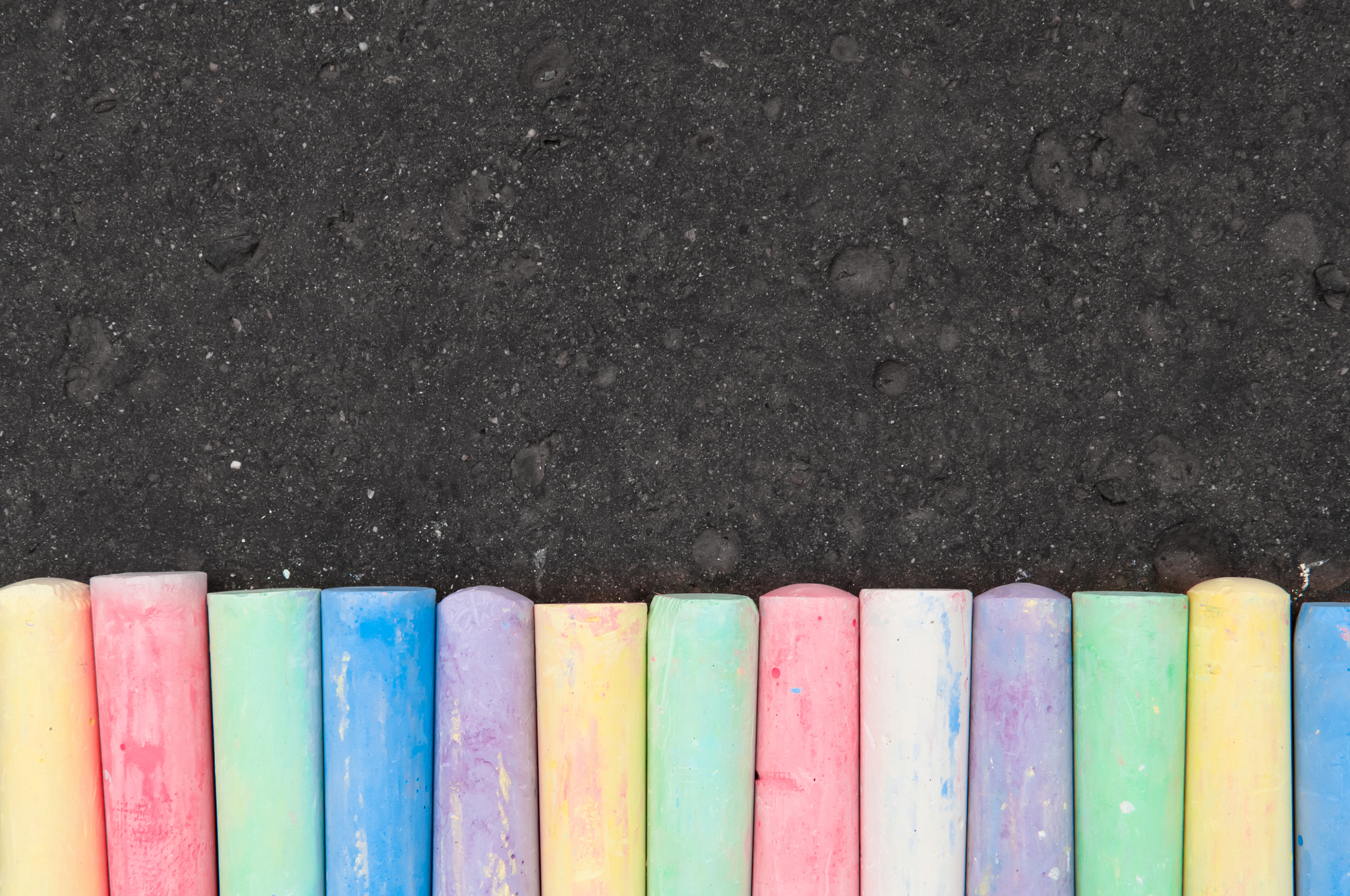 Nikon D2X sample photo. Colorful pastel sidewalk chalk on dark asphalt background. photography