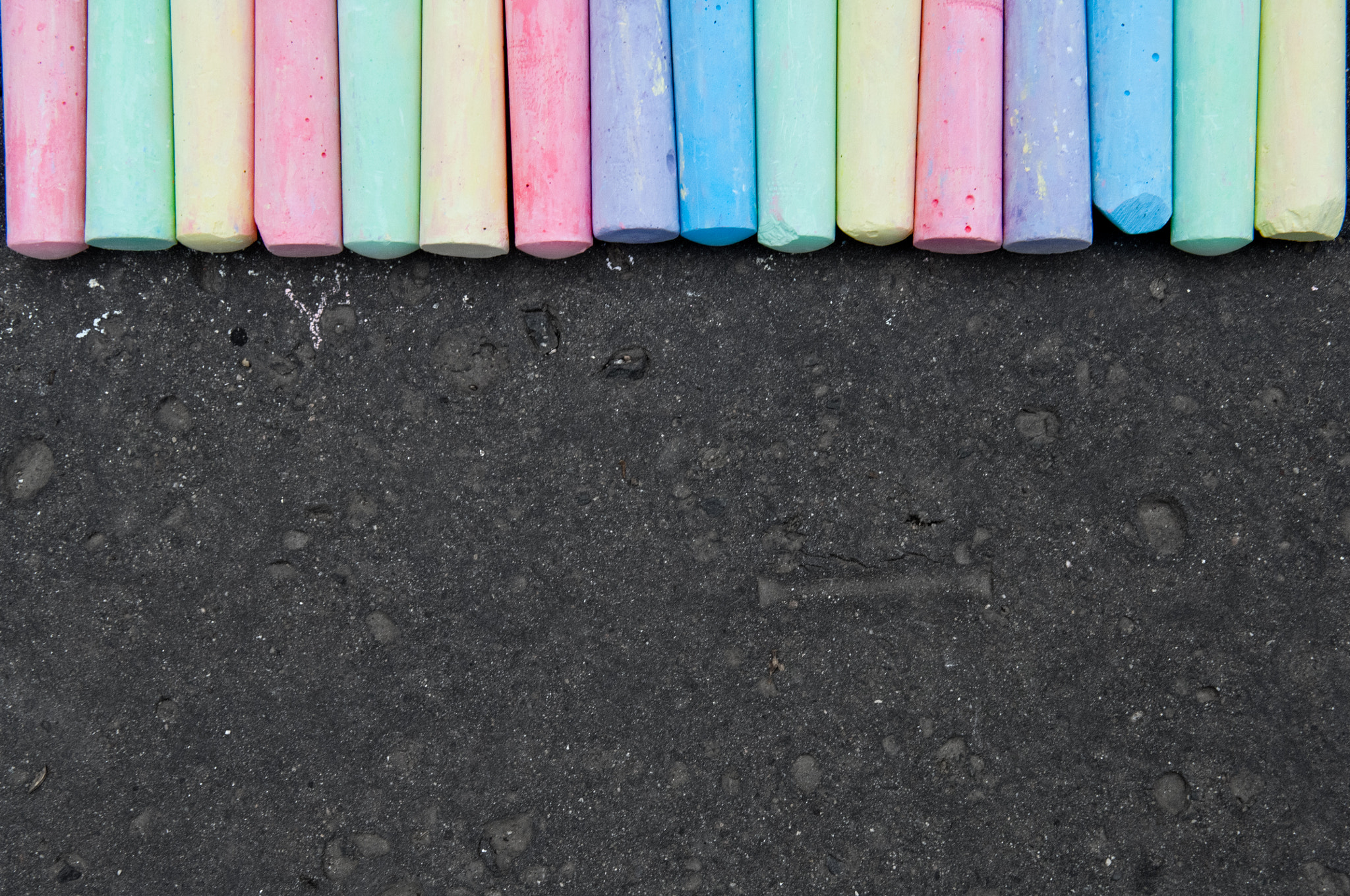 Nikon D2X sample photo. Colorful pastel sidewalk chalk on dark asphalt background. photography