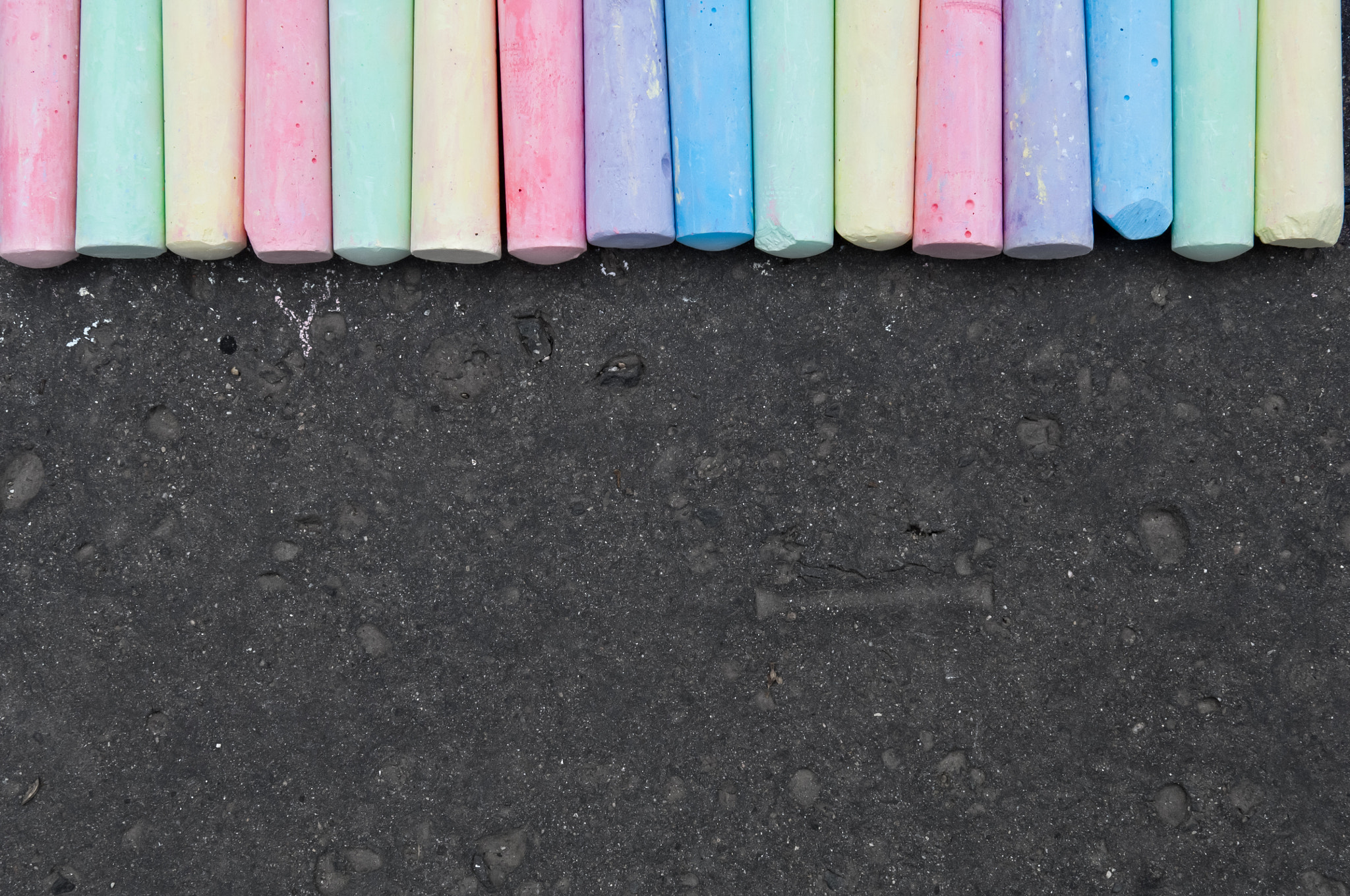 Nikon D2X sample photo. Colorful pastel sidewalk chalk on dark asphalt background. photography