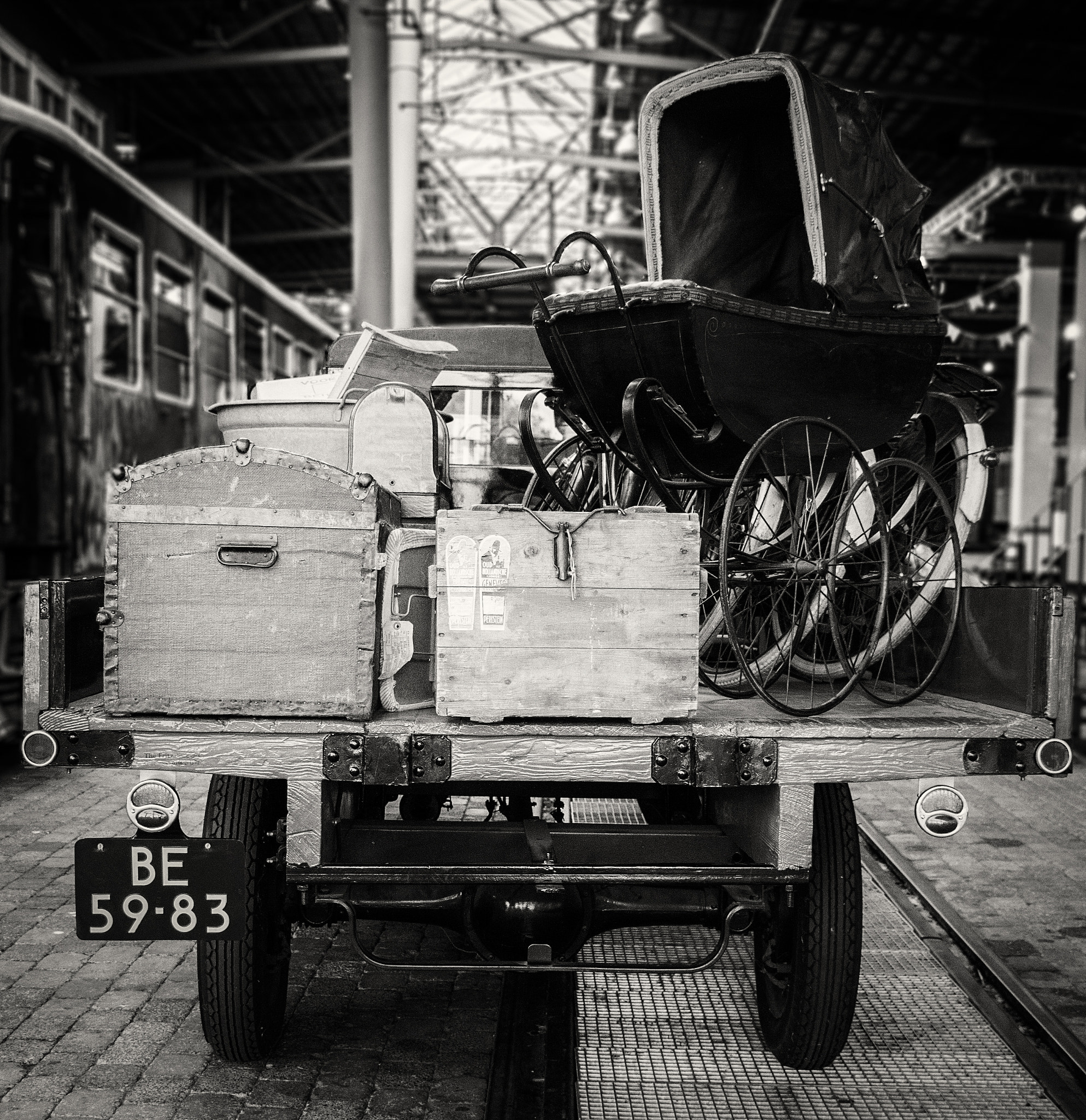 Canon EOS 1000D (EOS Digital Rebel XS / EOS Kiss F) sample photo. An old vehicle parked at a trainstation, captured in a style to reflect it's time period. photography